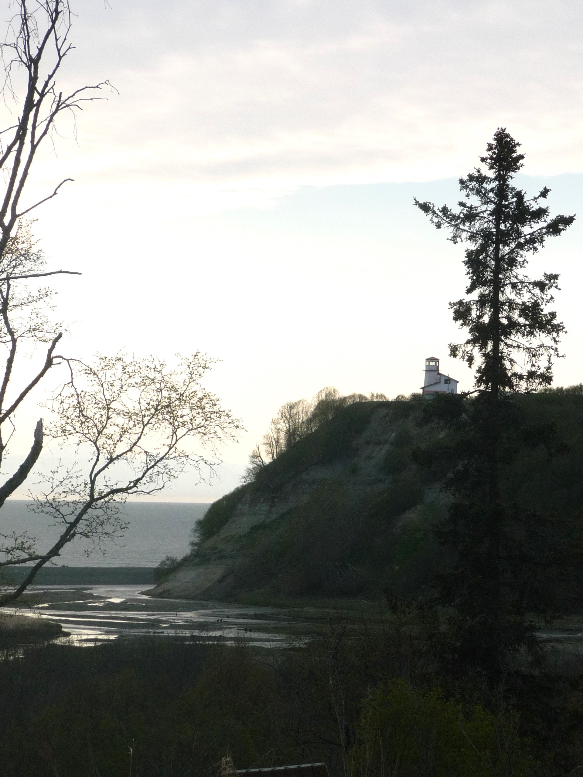 View of a light house on a cliff late in the day