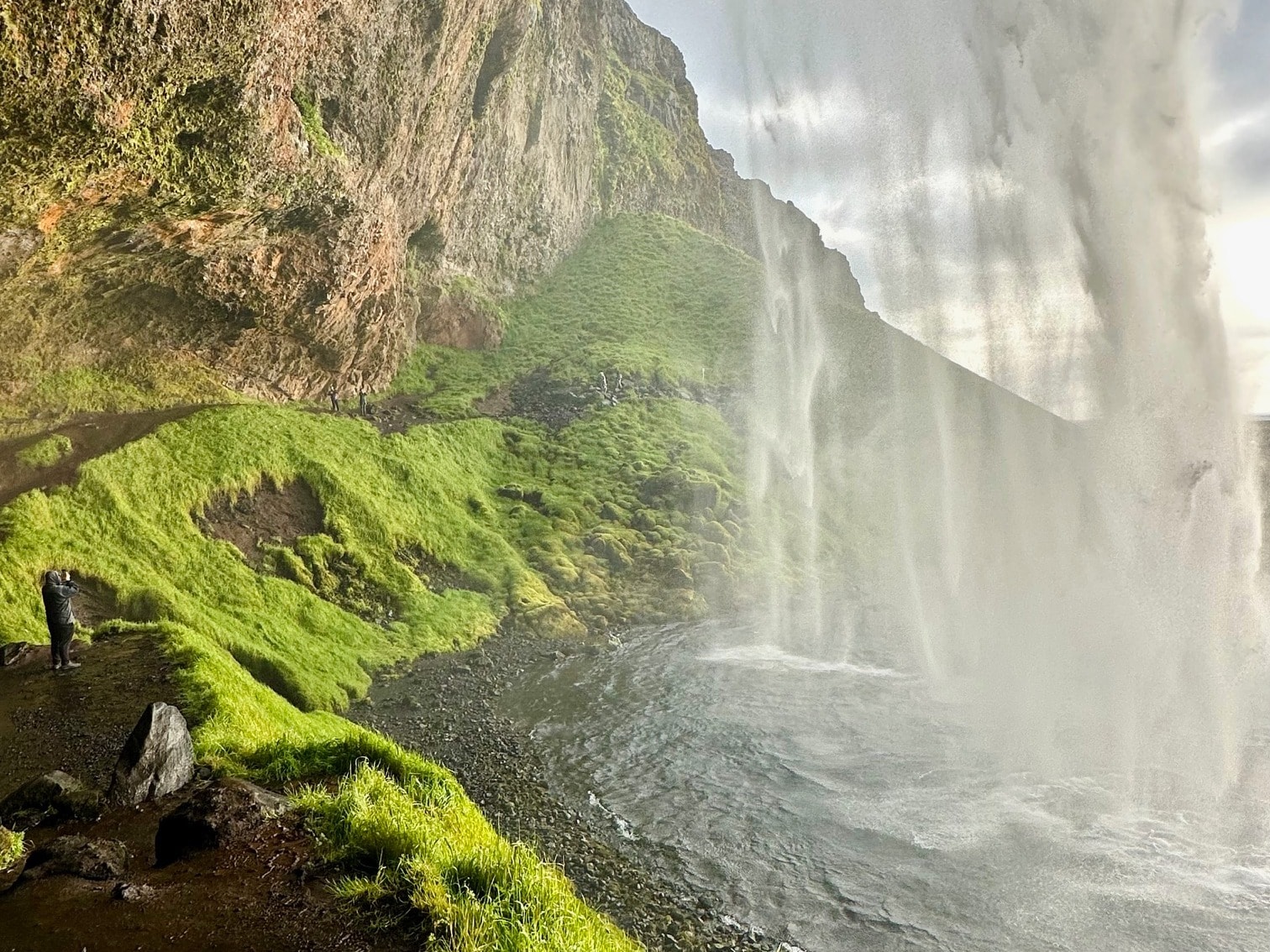 View of waterfall from under a mountain.