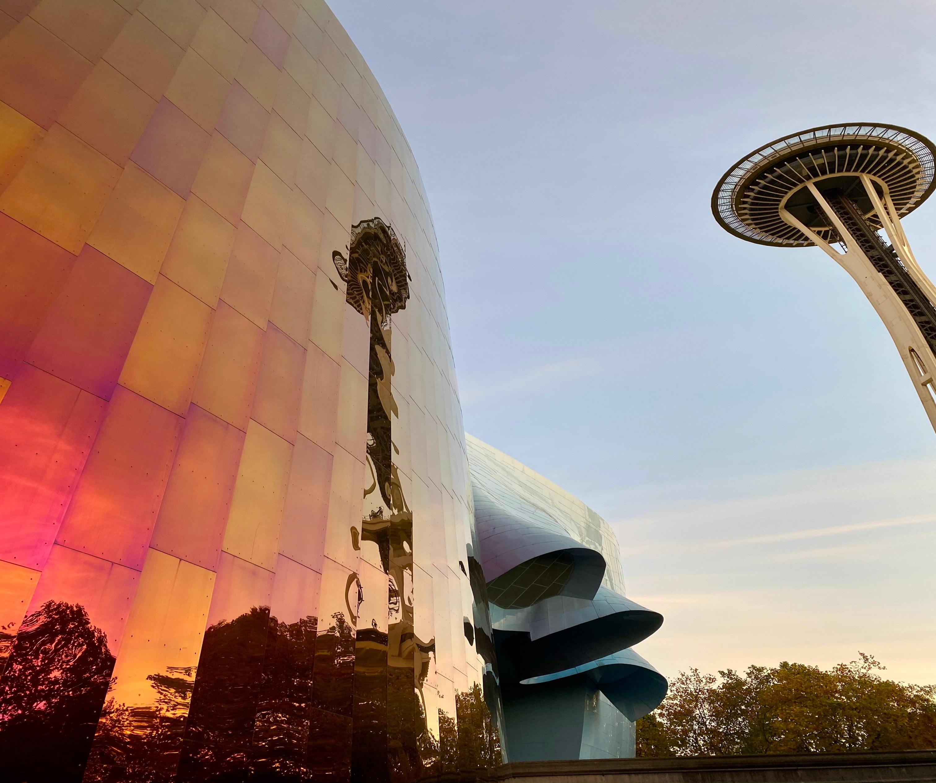 A view of the Seattle space needle next to a reflective wall. 