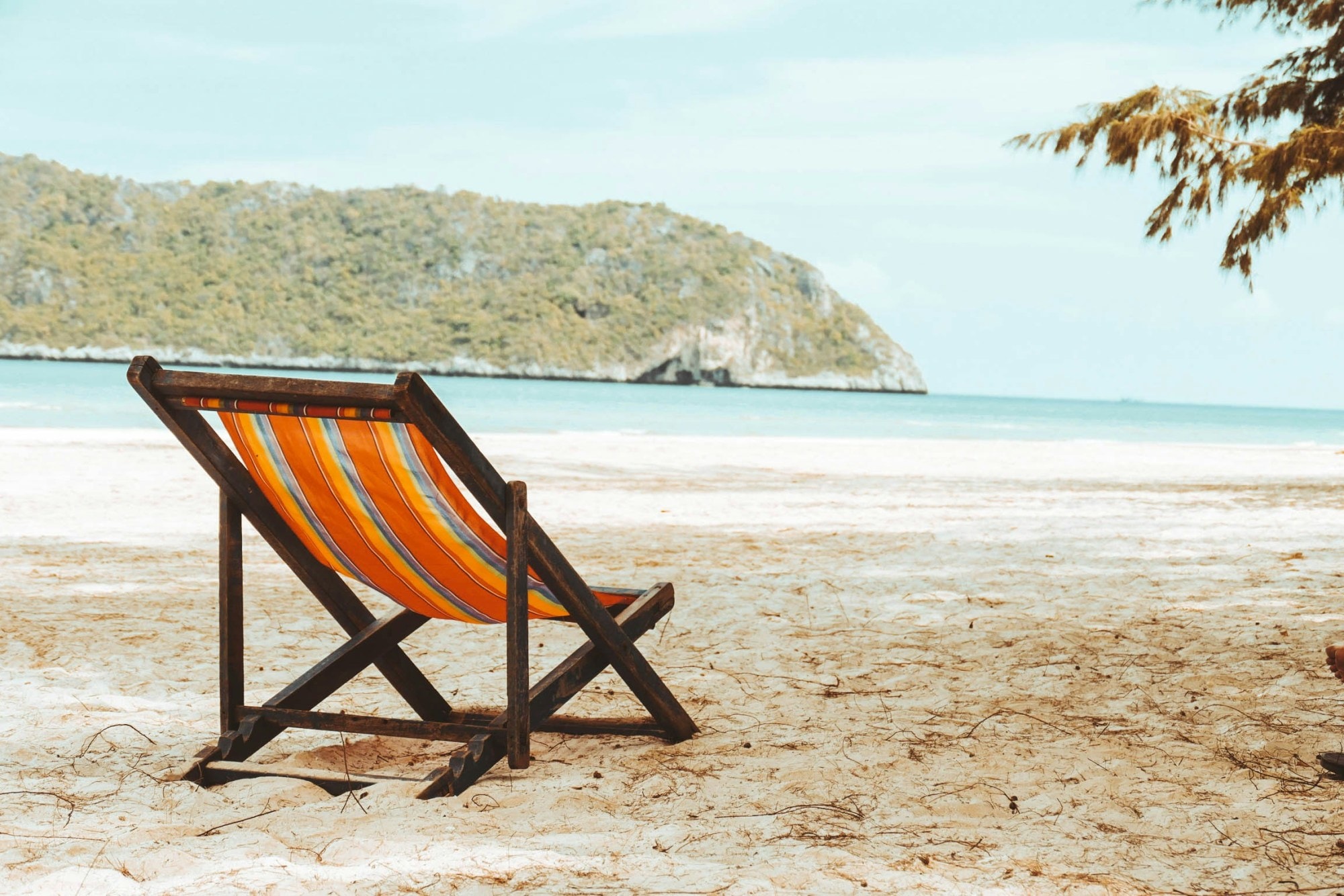 Orange striped lounge chair on a beach.