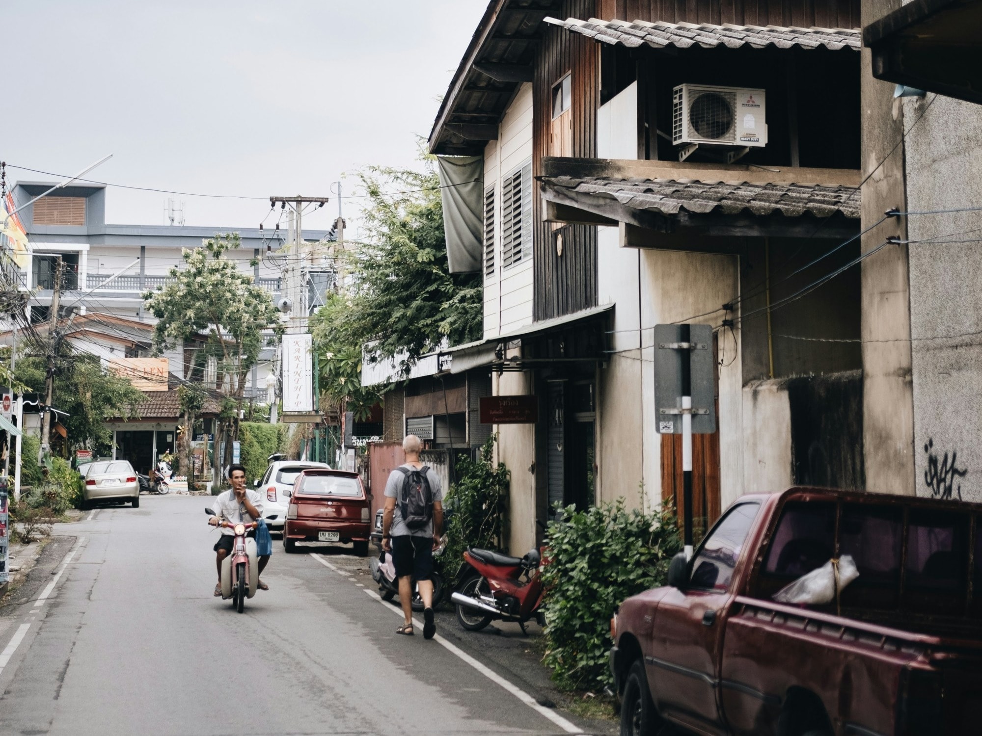 Person riding motorcycle in a quaint street. 