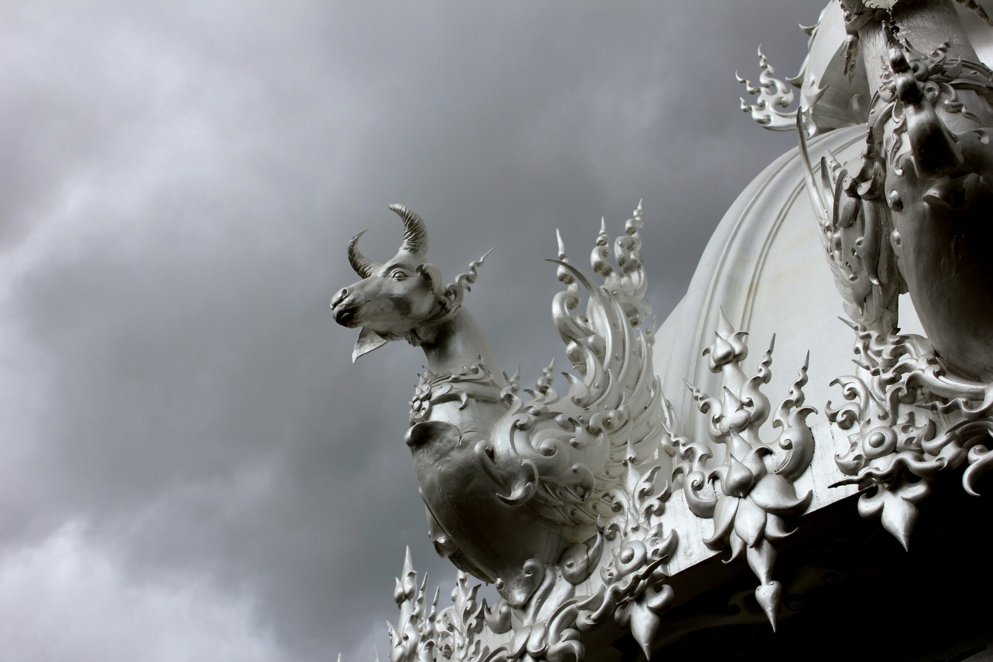 Black and white picture of building with statue of horned animal.