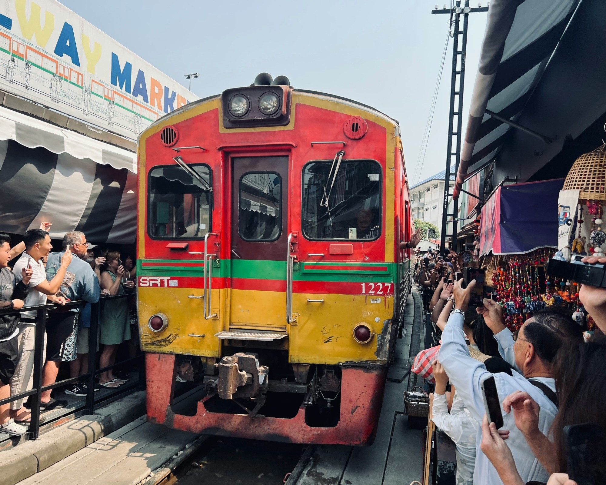 Crowds standing around a red and yellow train.