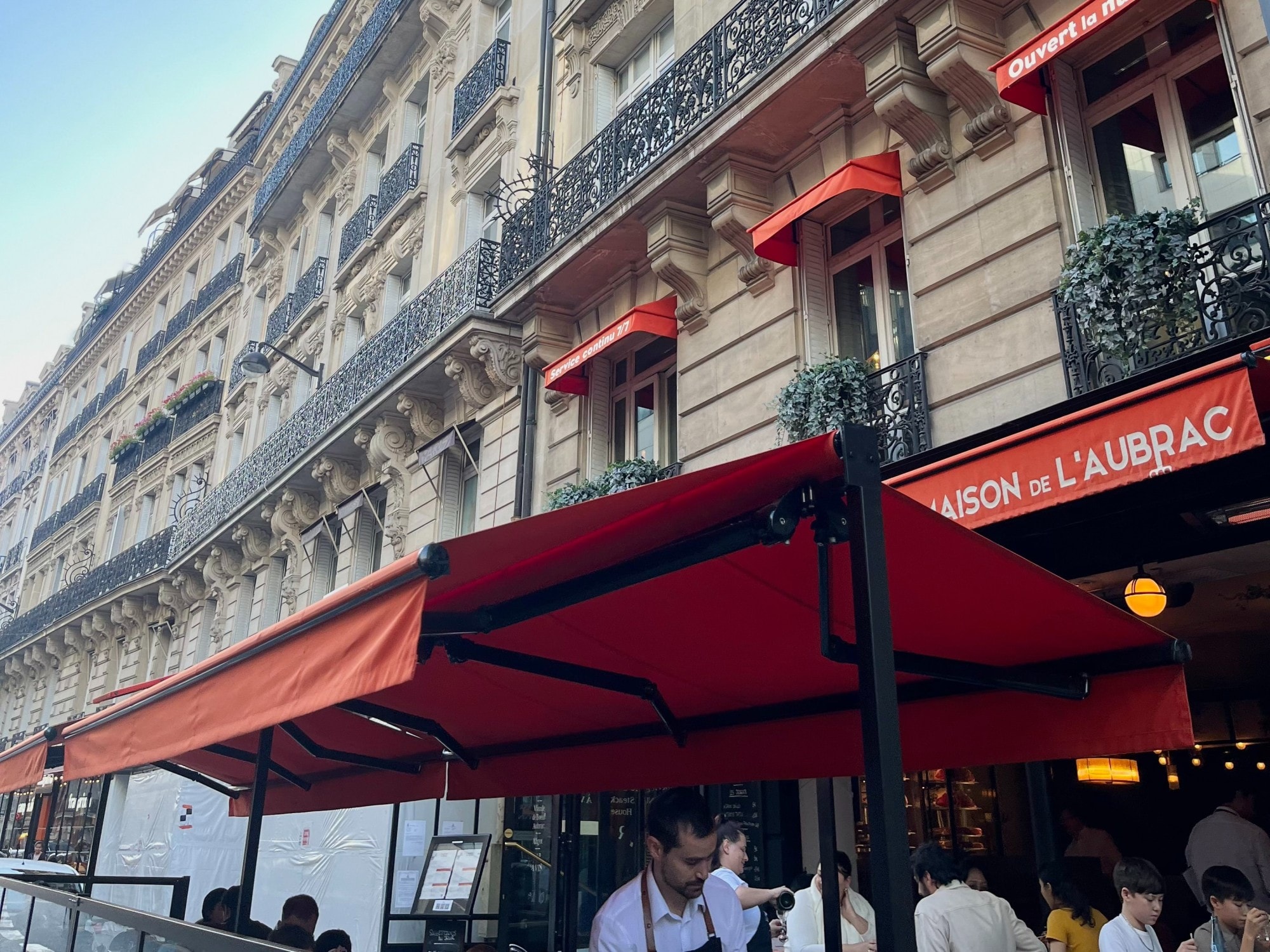 The outside of a restaurant with orange umbrellas