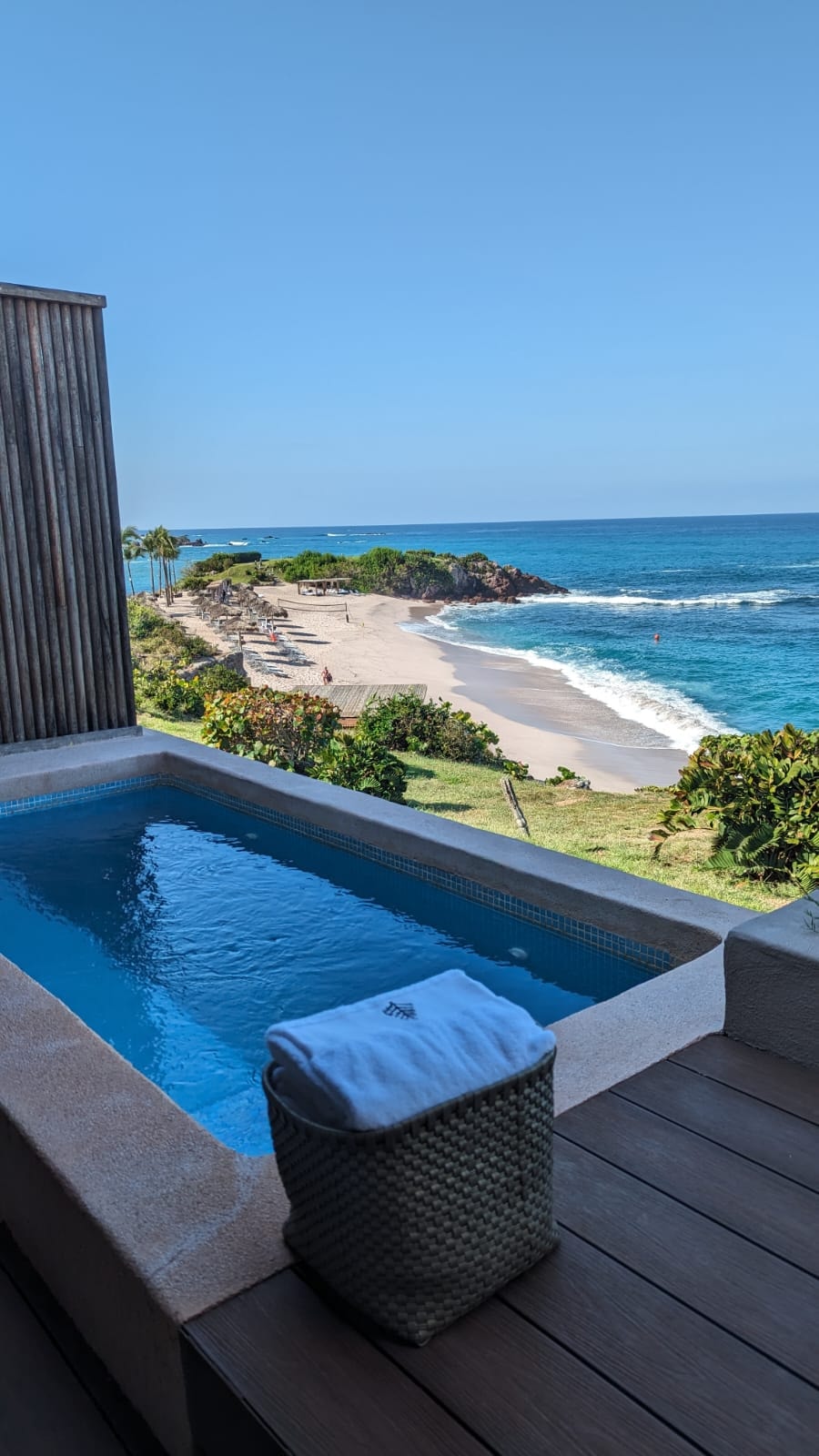 A small pool on a balcony out looking the beach