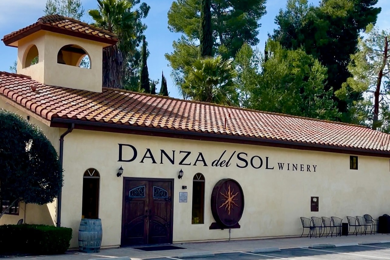 A Spanish-style yellow building with red roof and "Danza del Sol Winery" painted on the side.