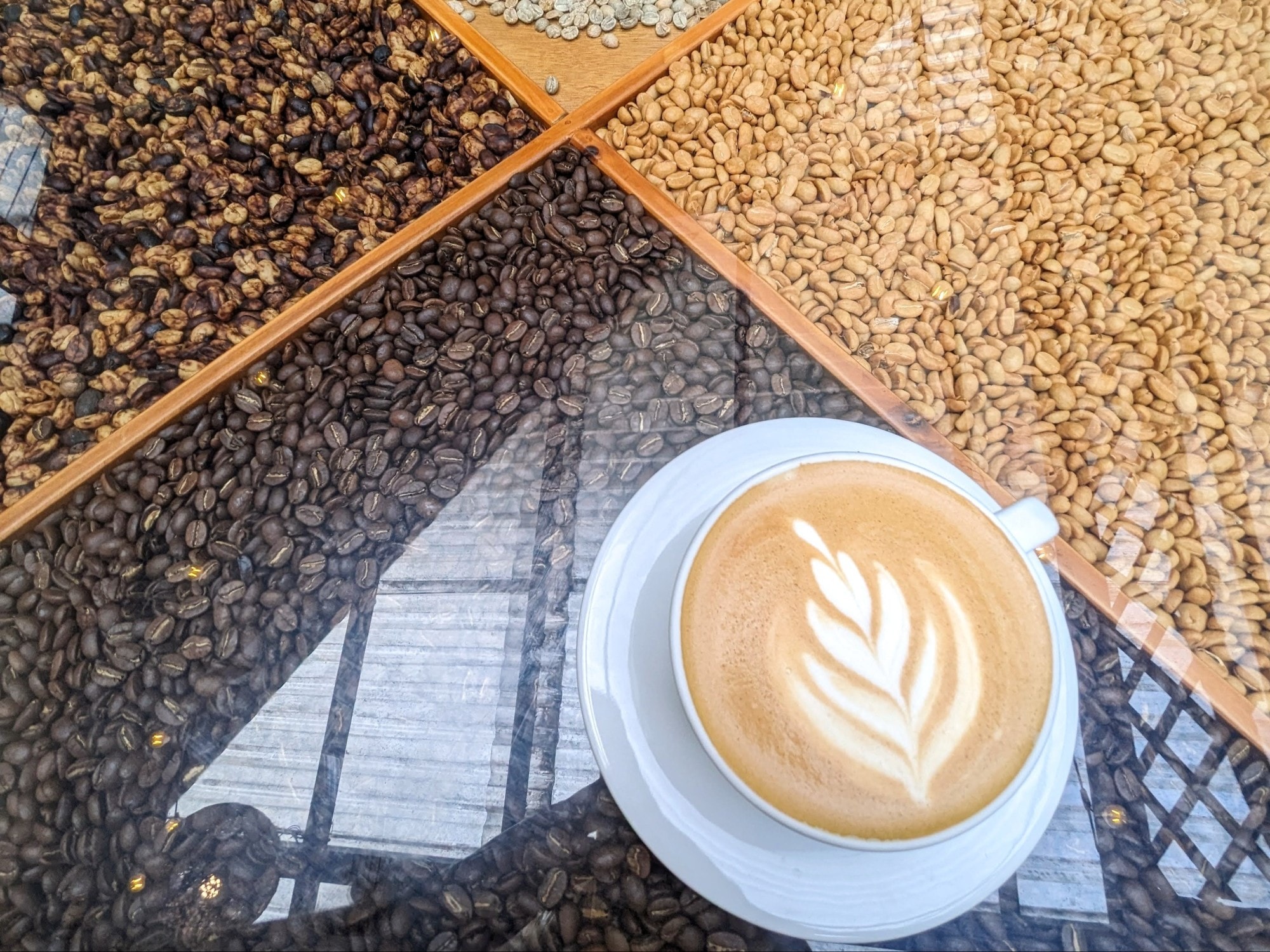 Latte on a table with coffee beans.