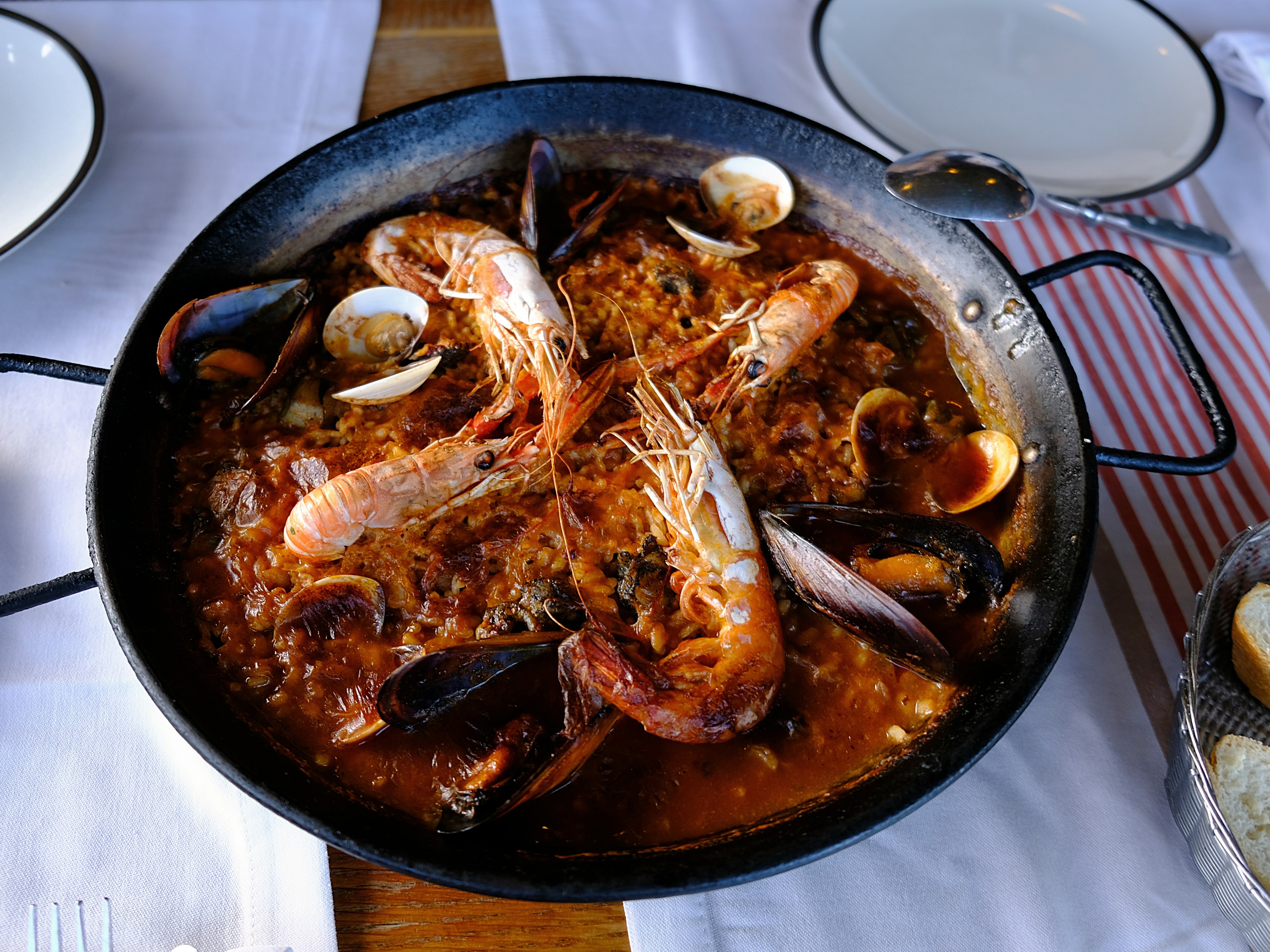 A picture of cooked shrimp on black round plate.