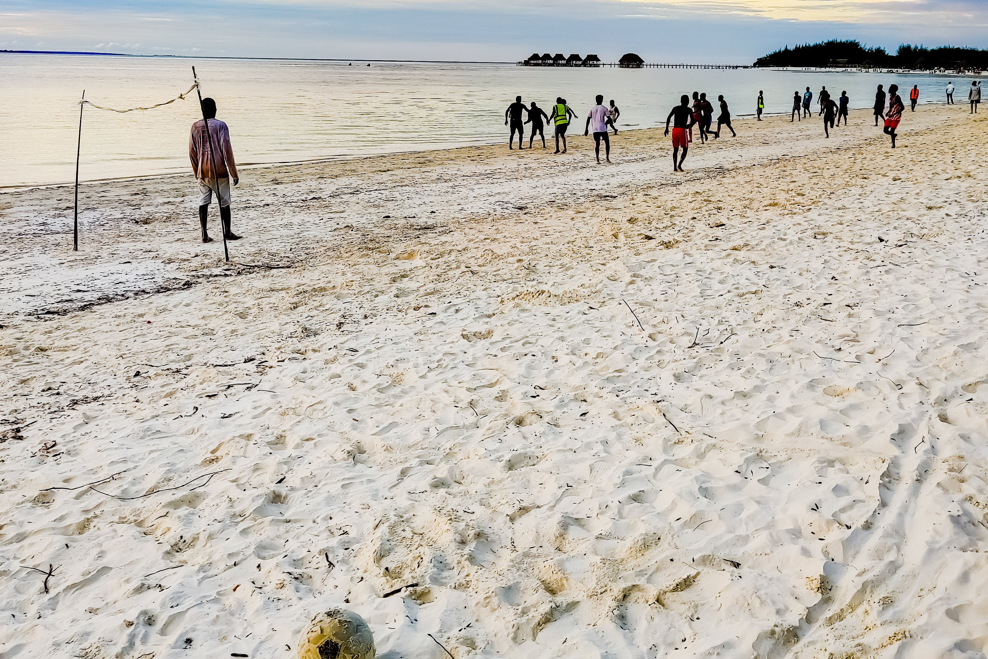 People playing soccer at the beach.