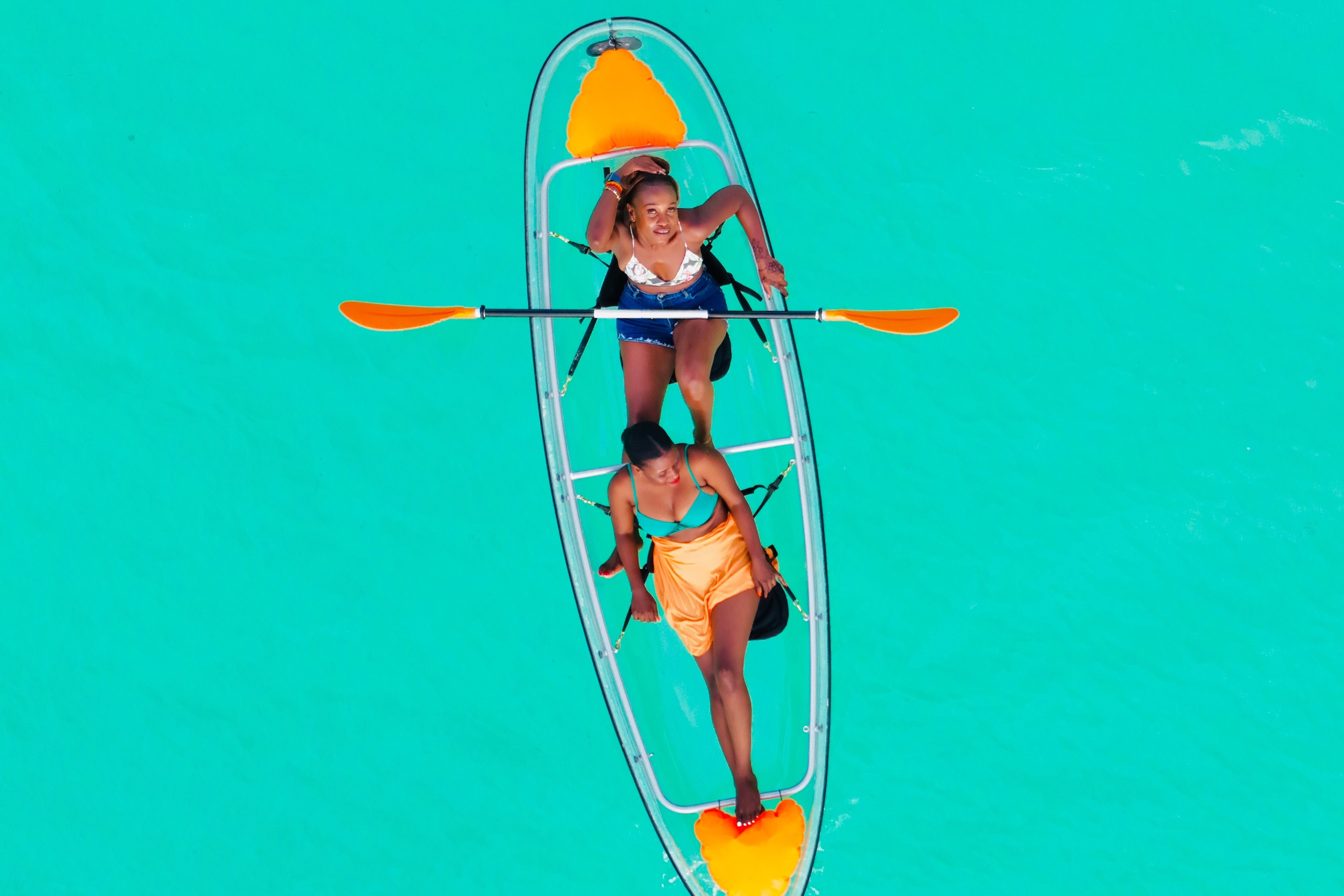 Two people canoeing in a clear boat