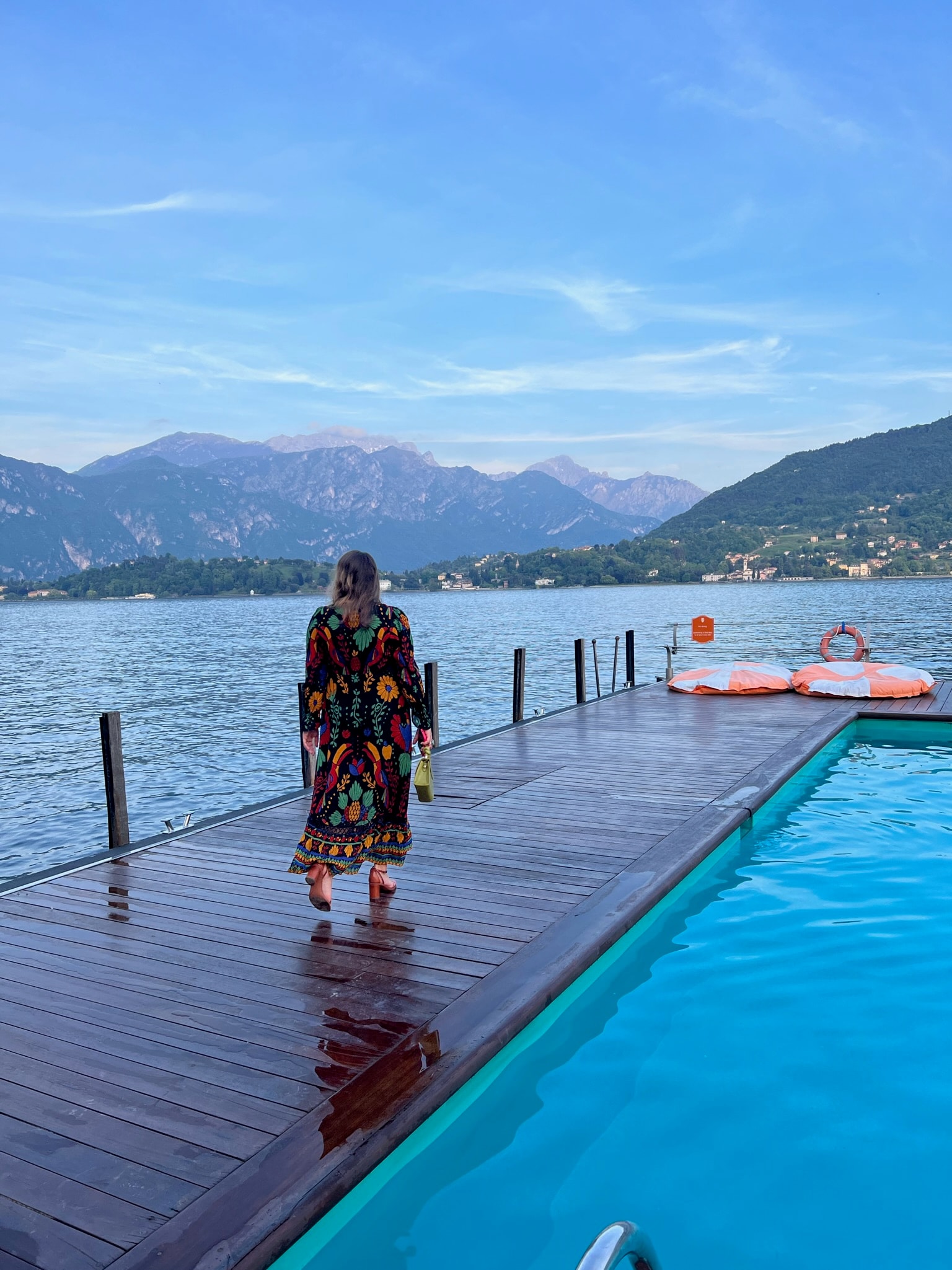 Picture of Gianna walking along the pool with beautiful lake view