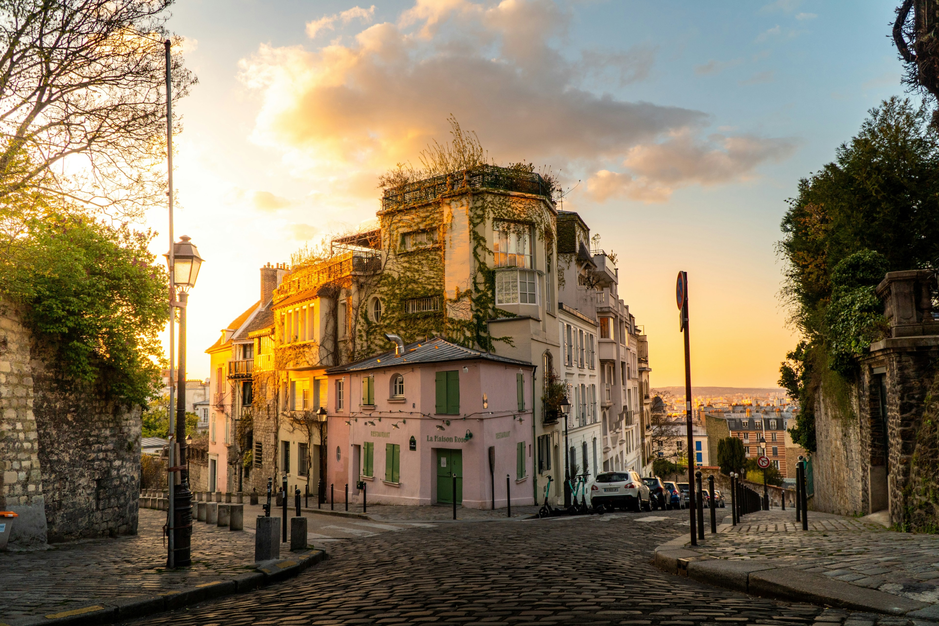 A picture of pink colored building connecting two roads in Montmartre.