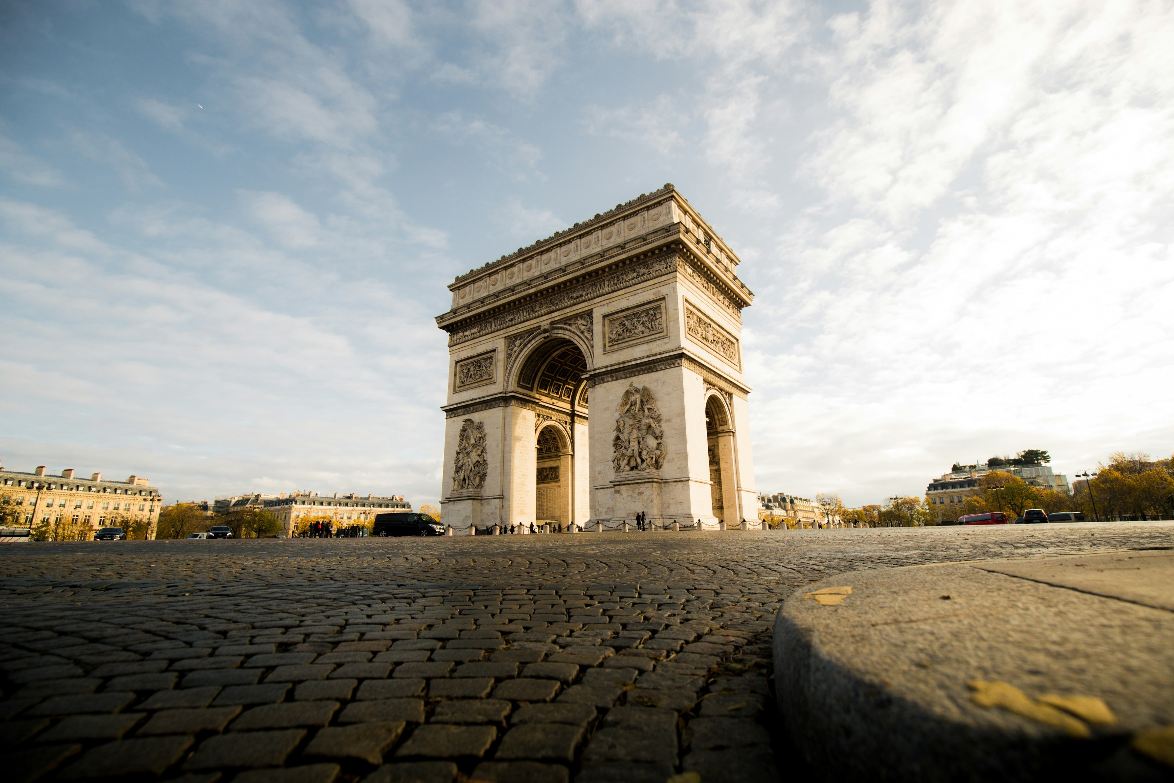 A low angled shot of the Arc de Triomphe during the daytime.