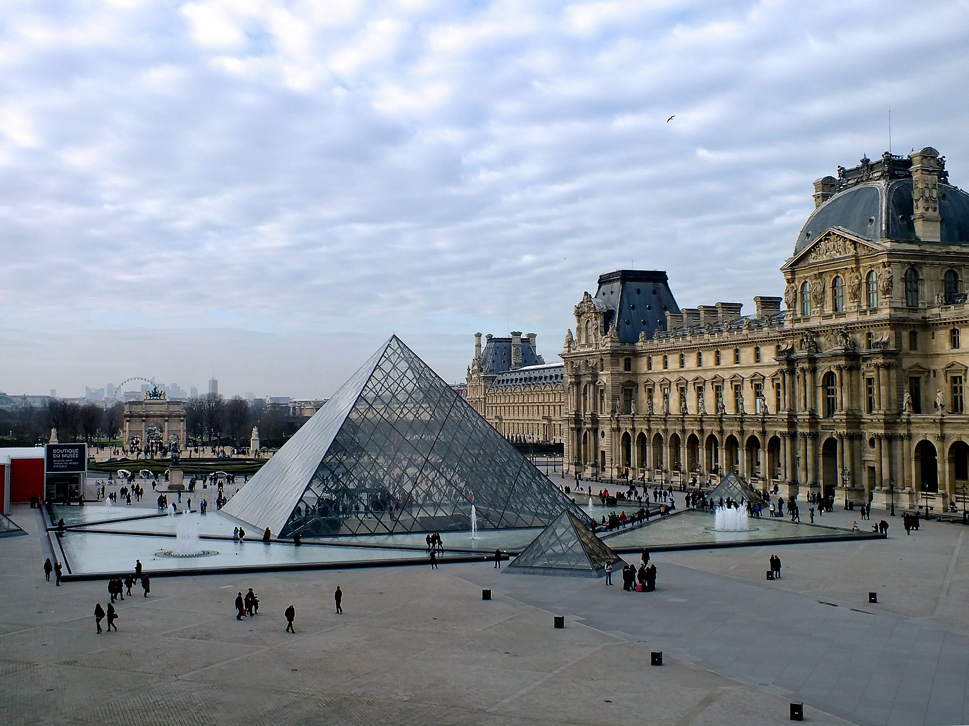 An aerial view of the Louvre Museum made out of glass during the daytime.