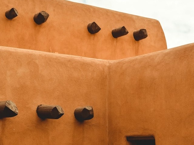 A terracotta building with wooden pillars sticking out