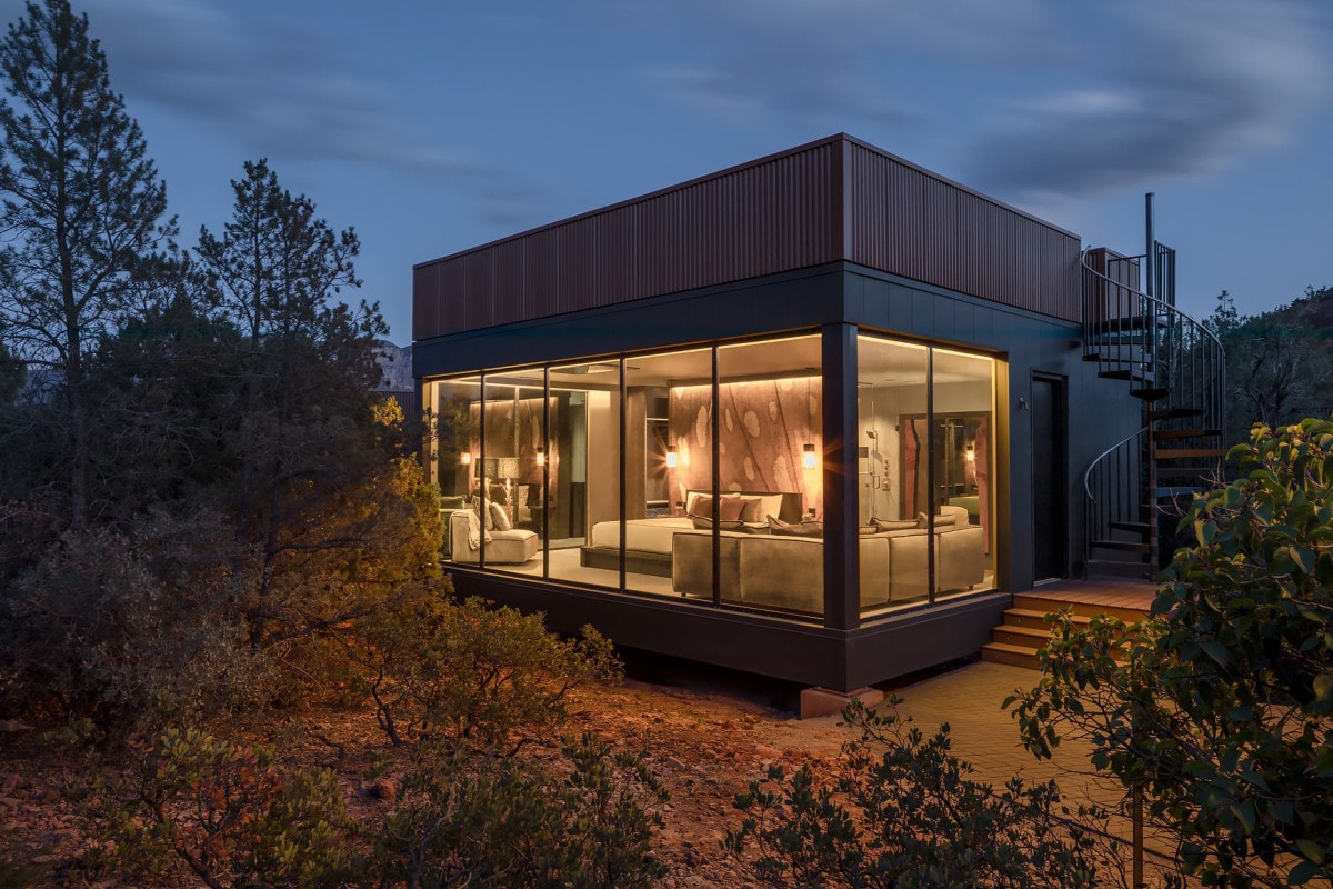 a cubic building with floor-to-ceiling windows and a spiral outdoor staircase