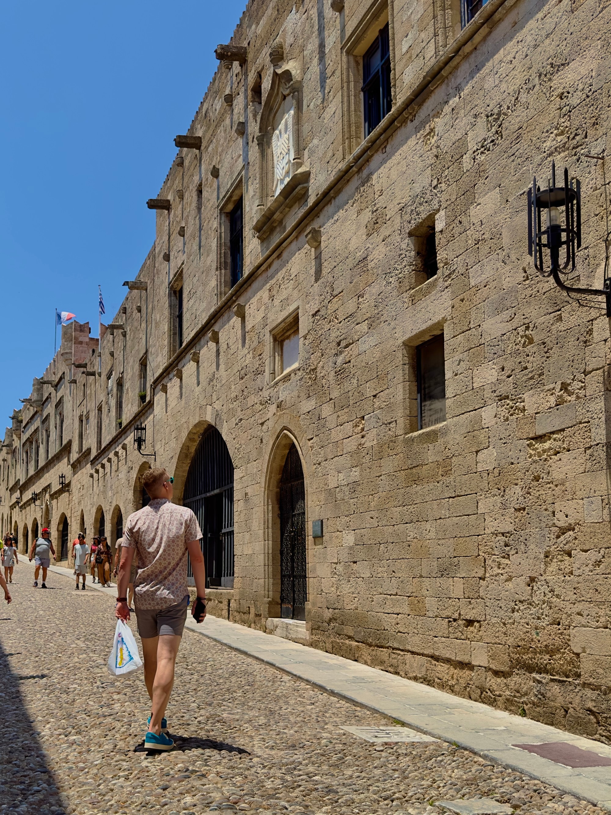 A person walking down a street with old brick buildings