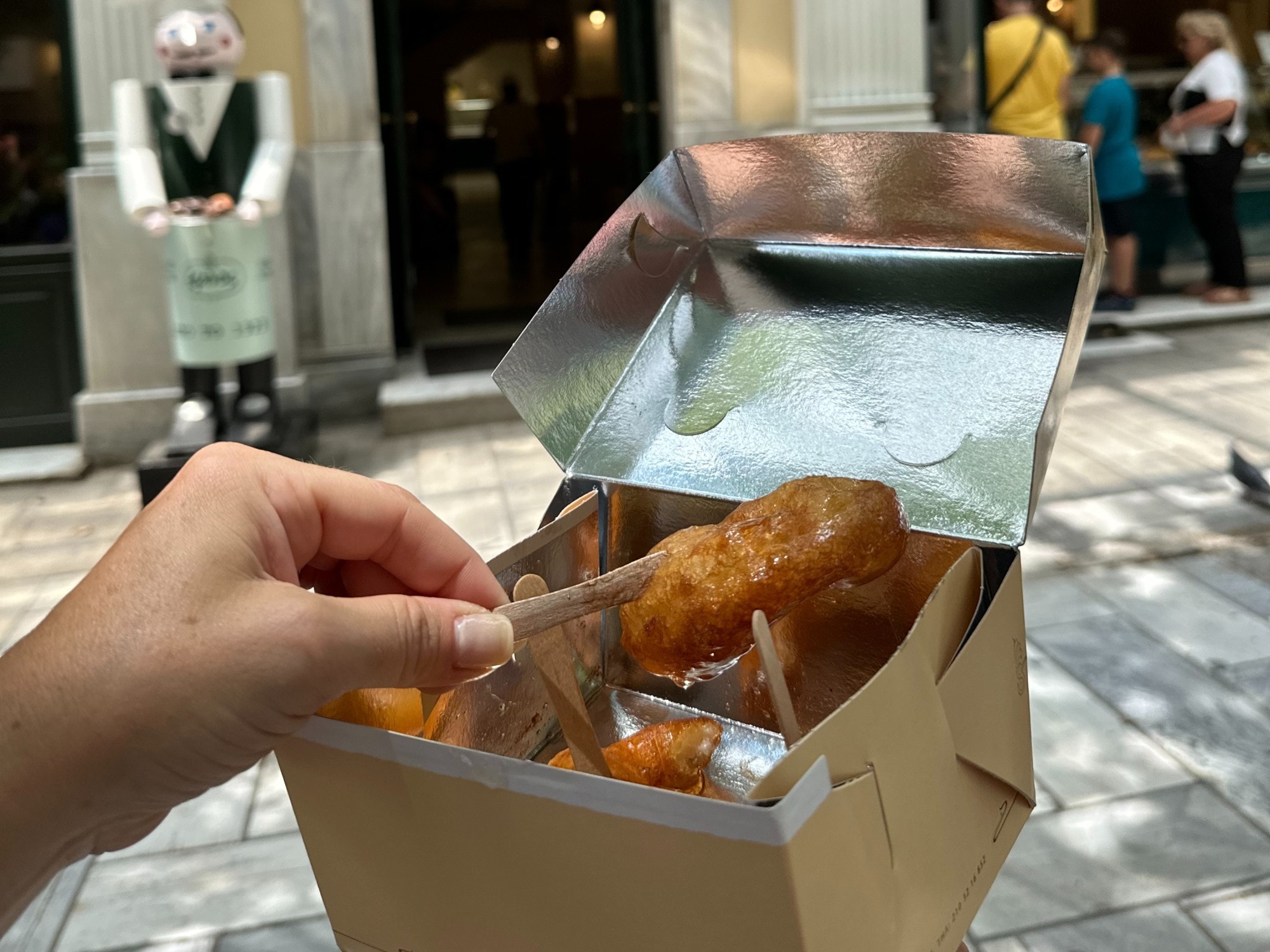 Food in a brown box in front of a restaurant.