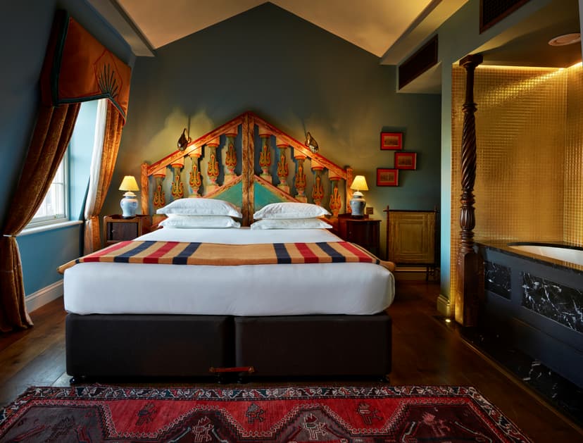 Junior Suite at The Zetter Clerkenwell, London with quirky, antique furnishing in dark, warm tones.