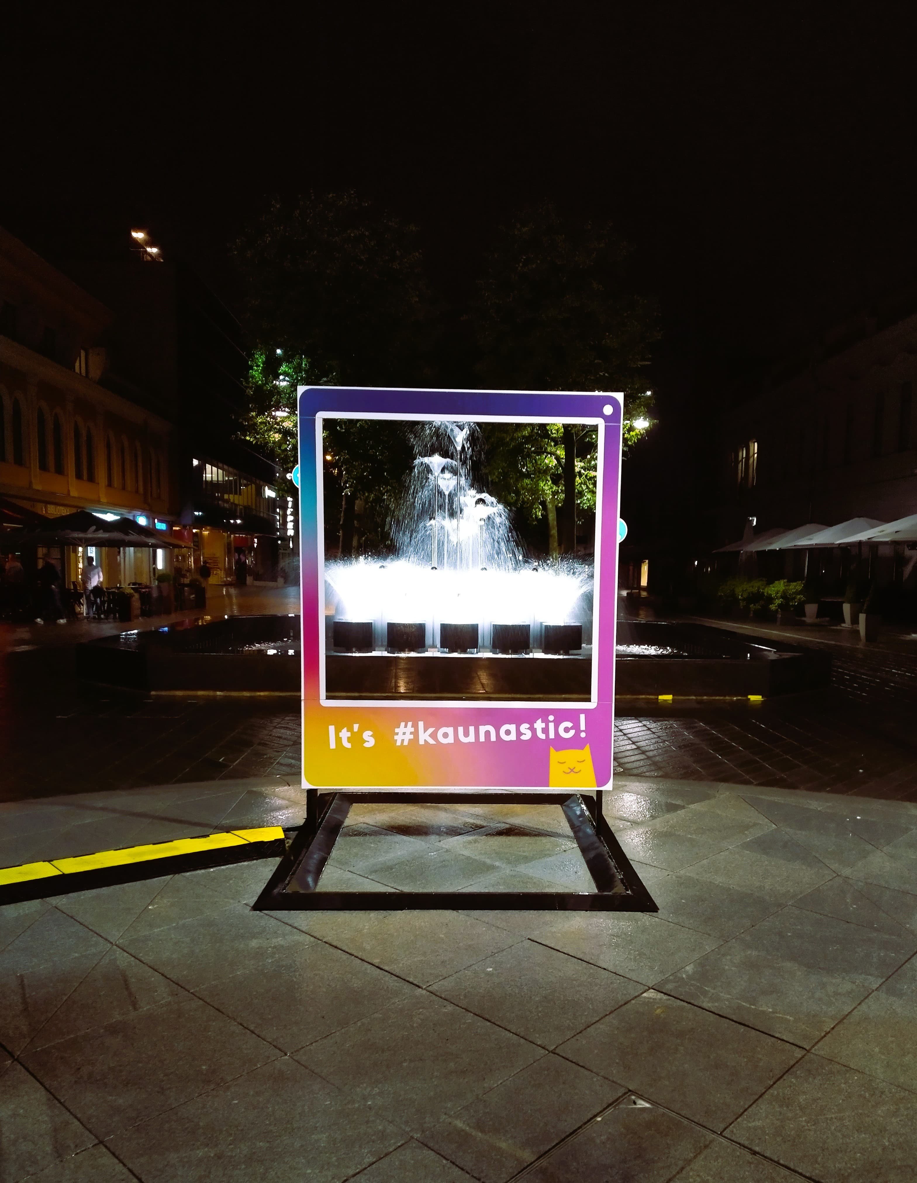 View of a fountain with a billboard in front