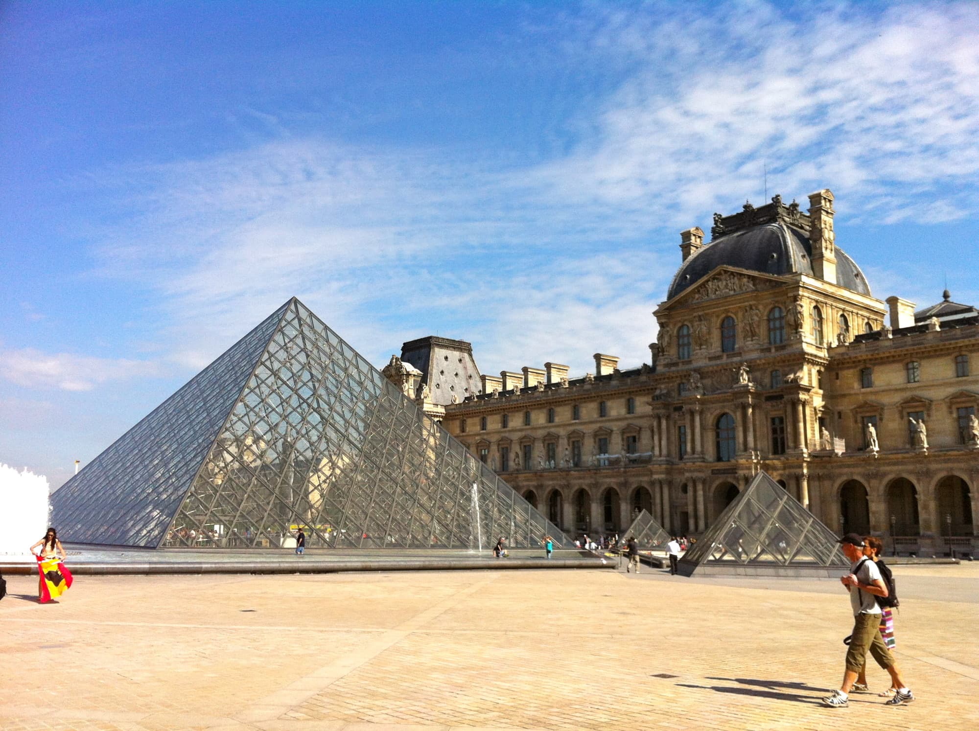 People walking near triangular buildings.
