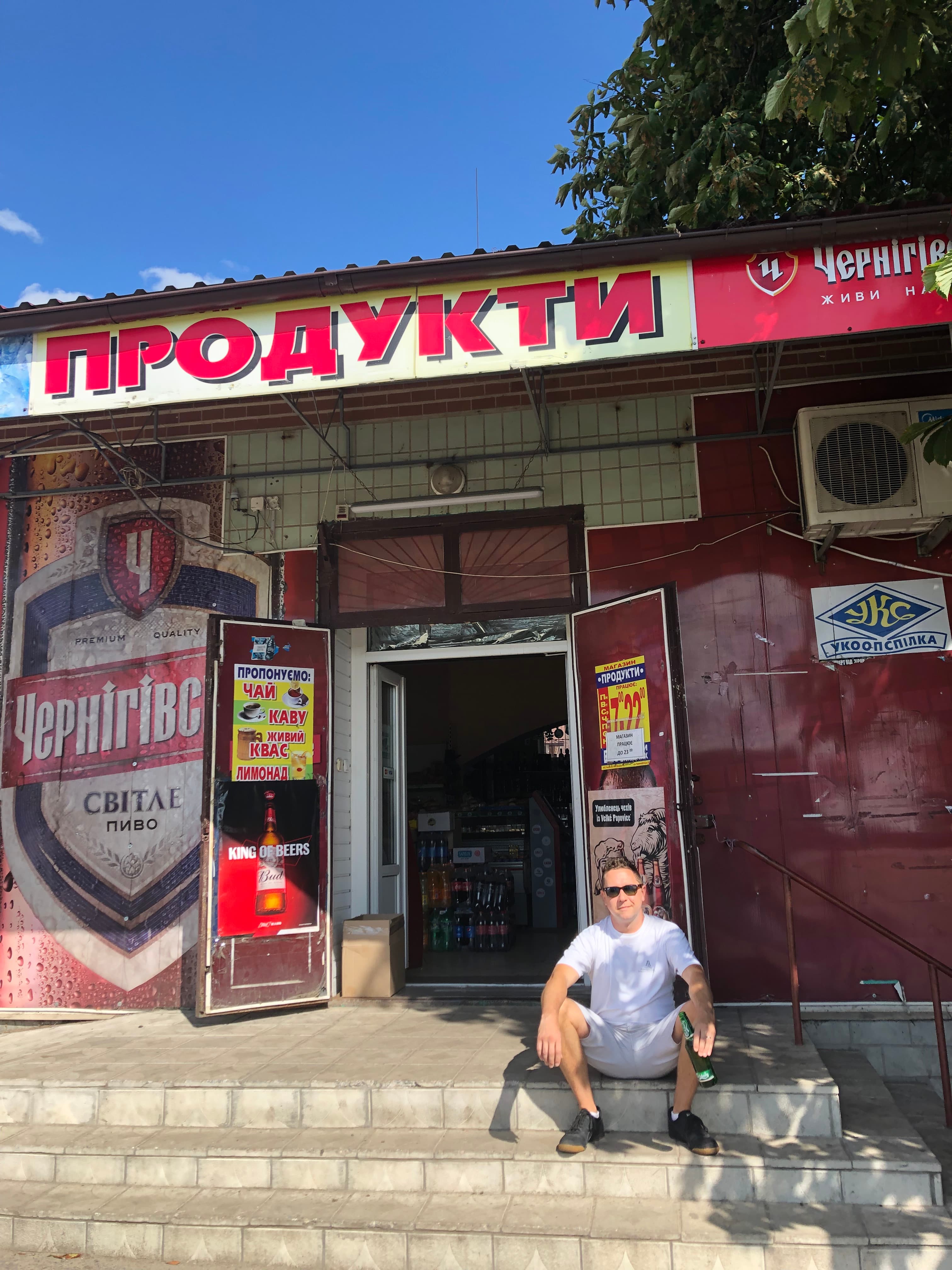 Picture of Chris sitting on stairs in front of store