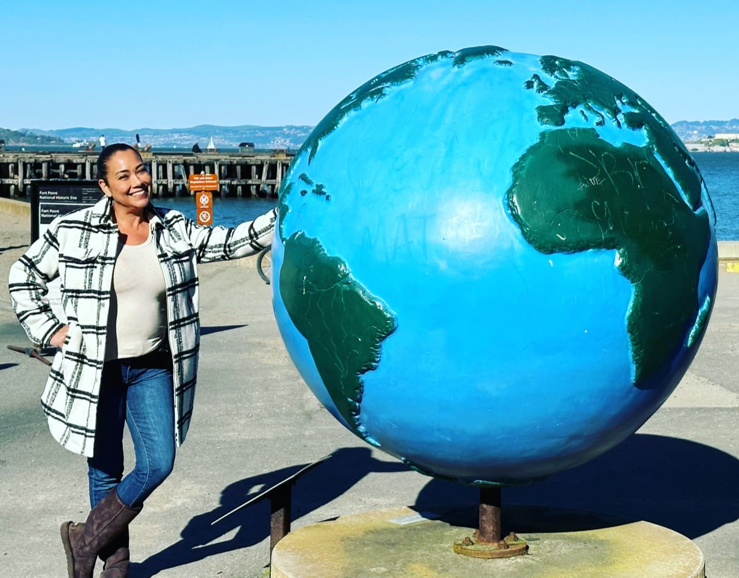Travel advisor Joanna Alejandro leans against a statue of the earth