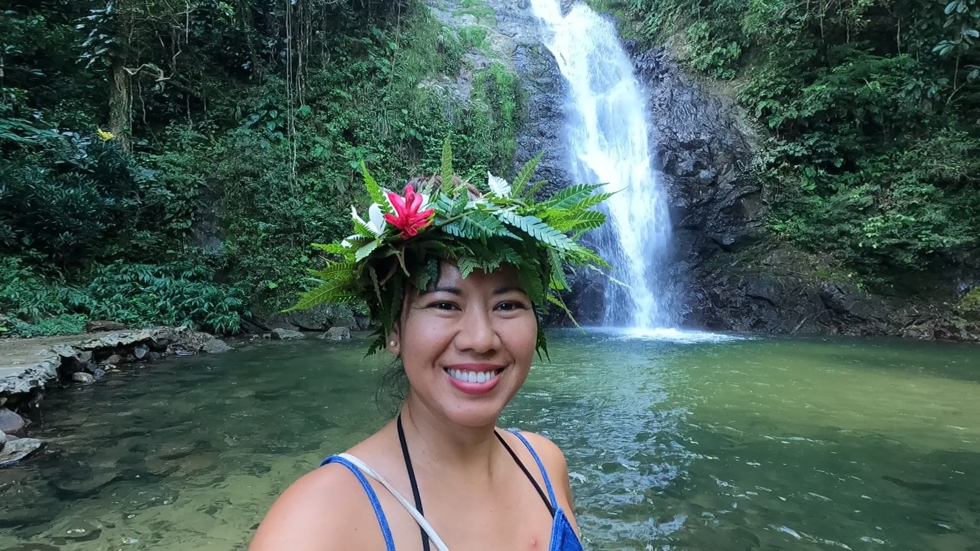 Travel advisor posing beside a waterfall