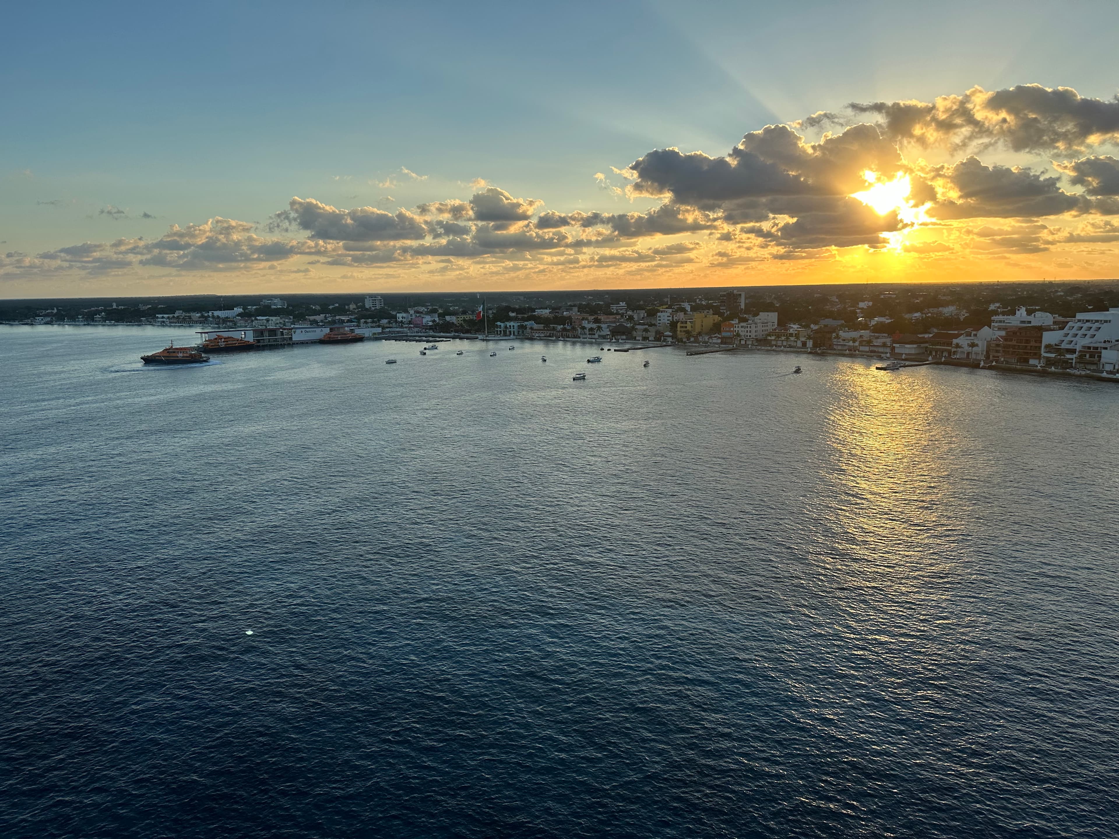 Picture of a beautiful sunset behind scattered clouds over a body of water