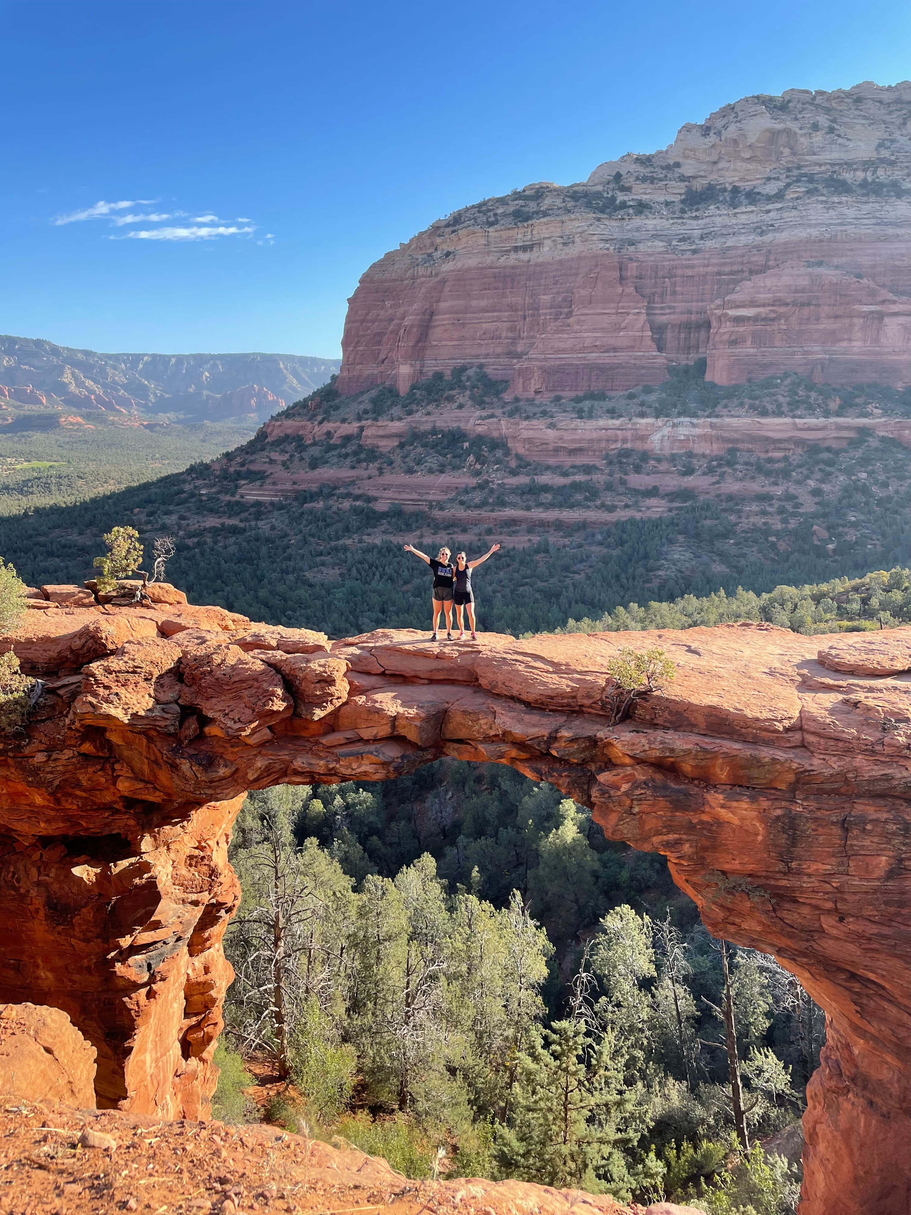 People standing on a rocky outlook against the Grand Canyon