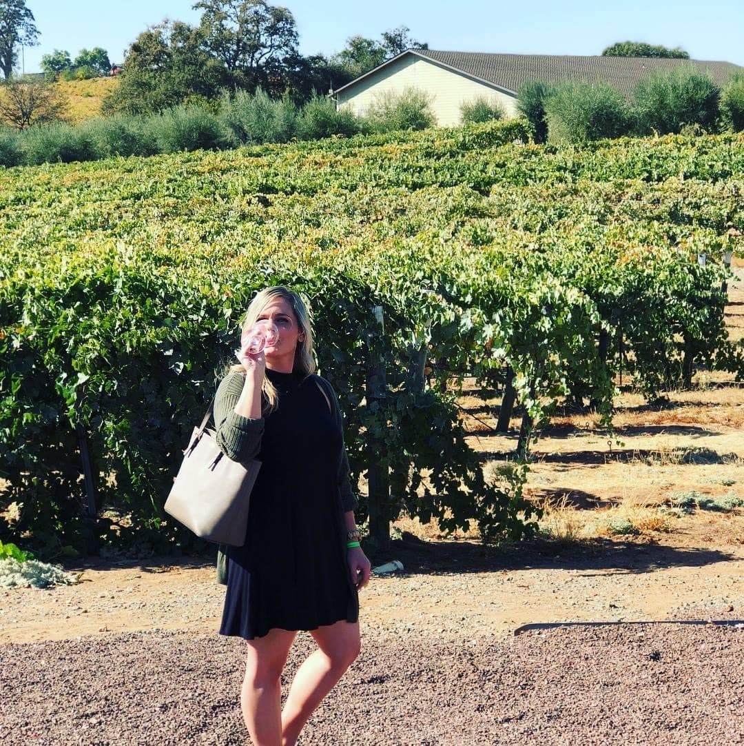 Picture of Nicole standing in a vineyard field.