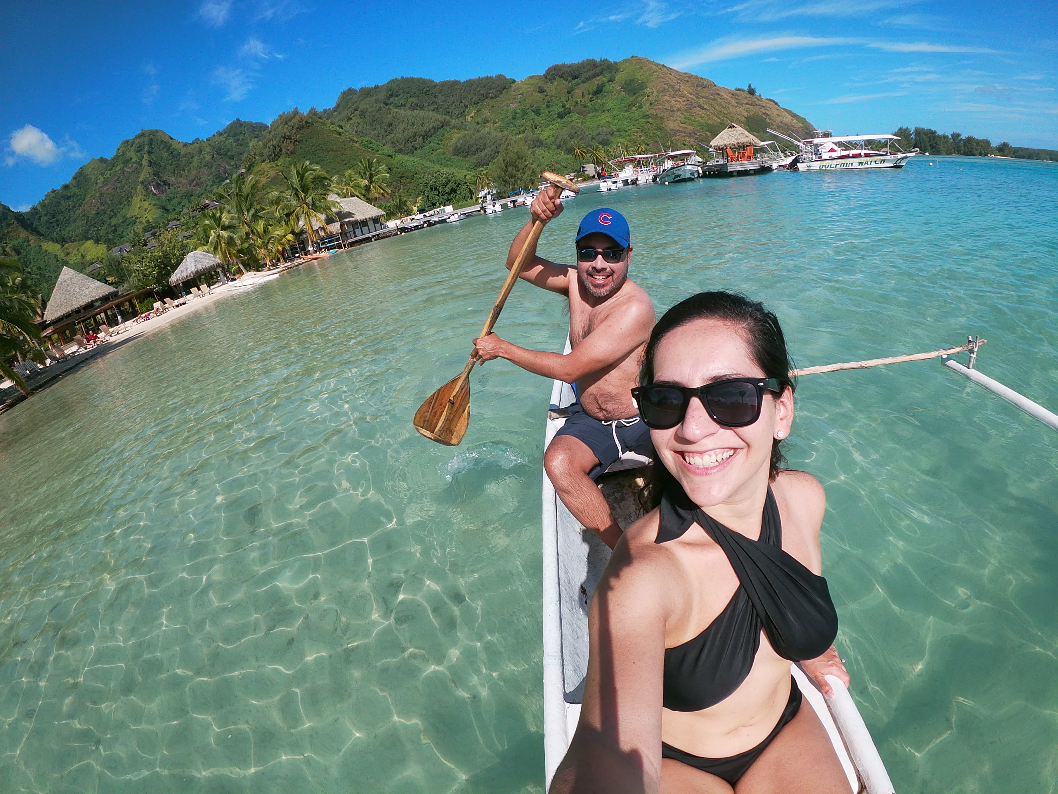 A couple smiling for a selfie on a boat in the water