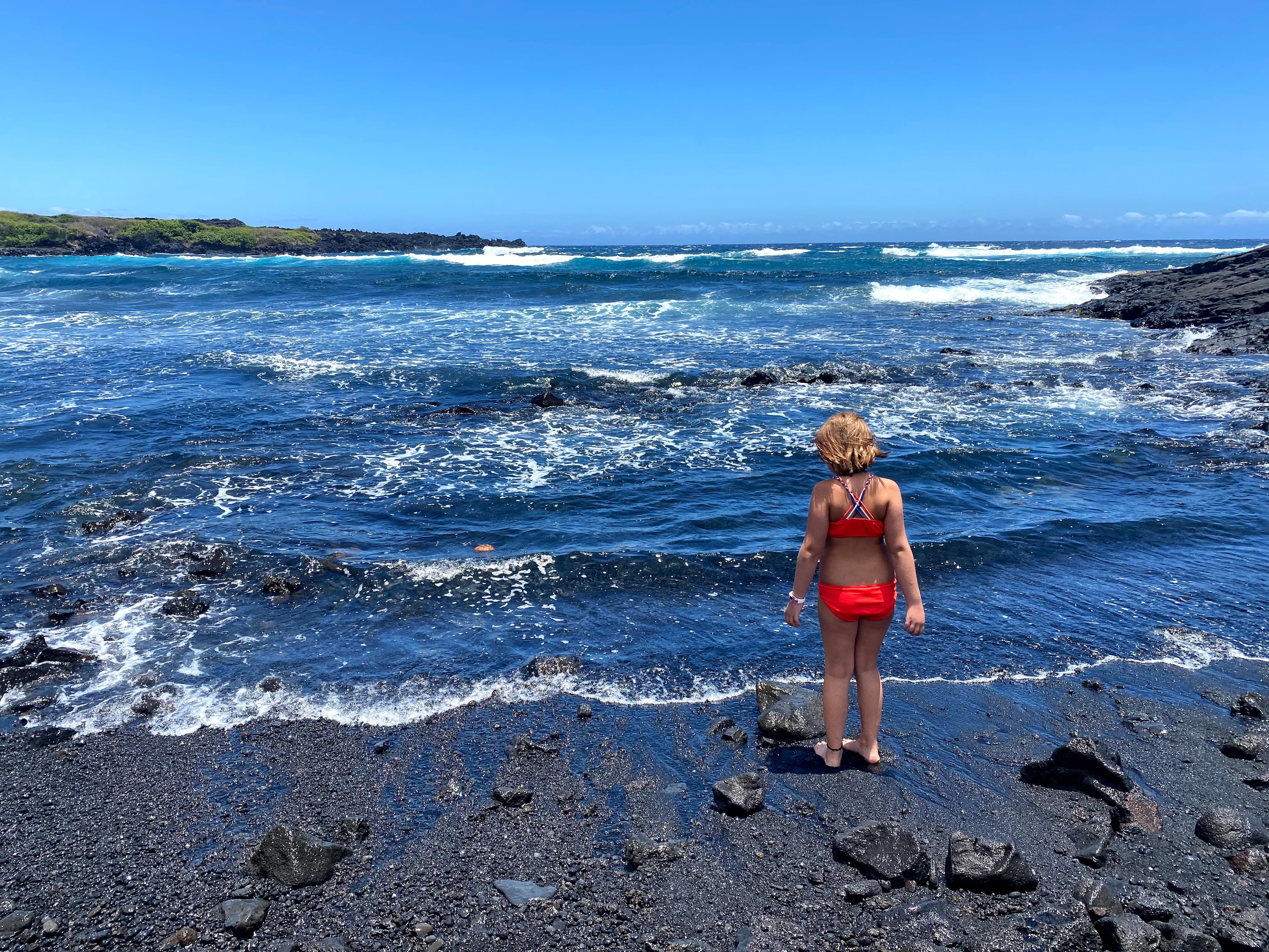 Girl on blacksand beach.