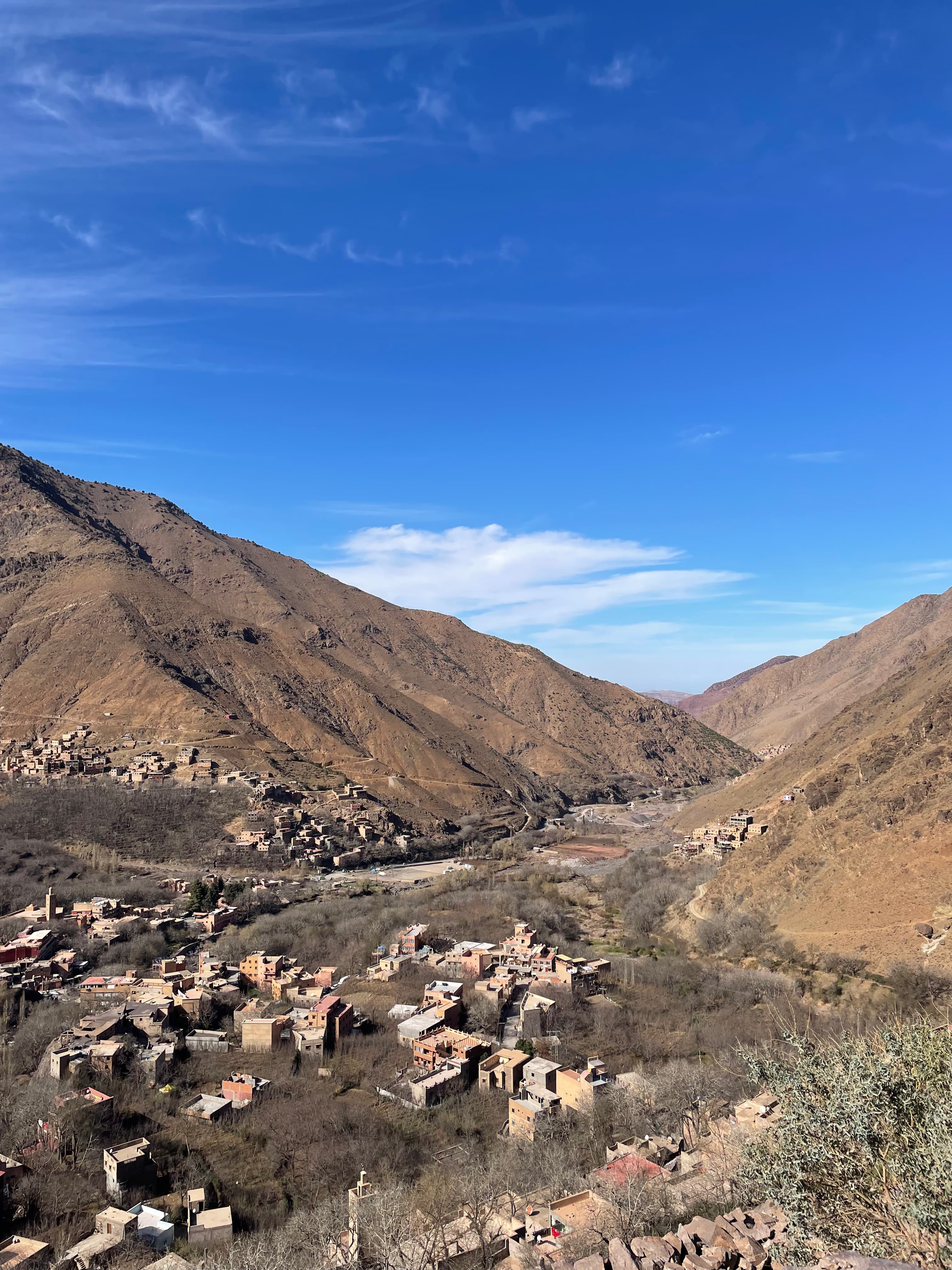 A view of the Atlas Mountains with small houses in the foreground.