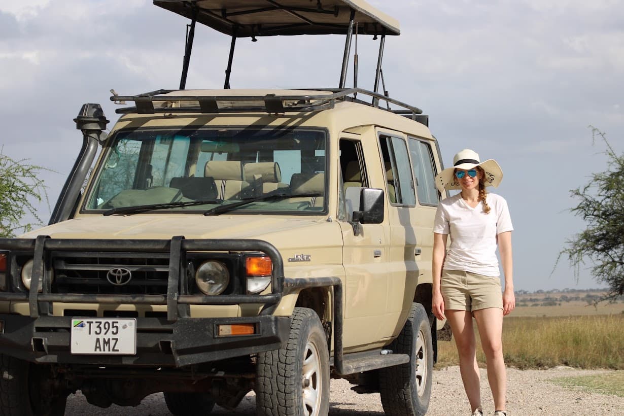 travel advisor stands with safari jeep