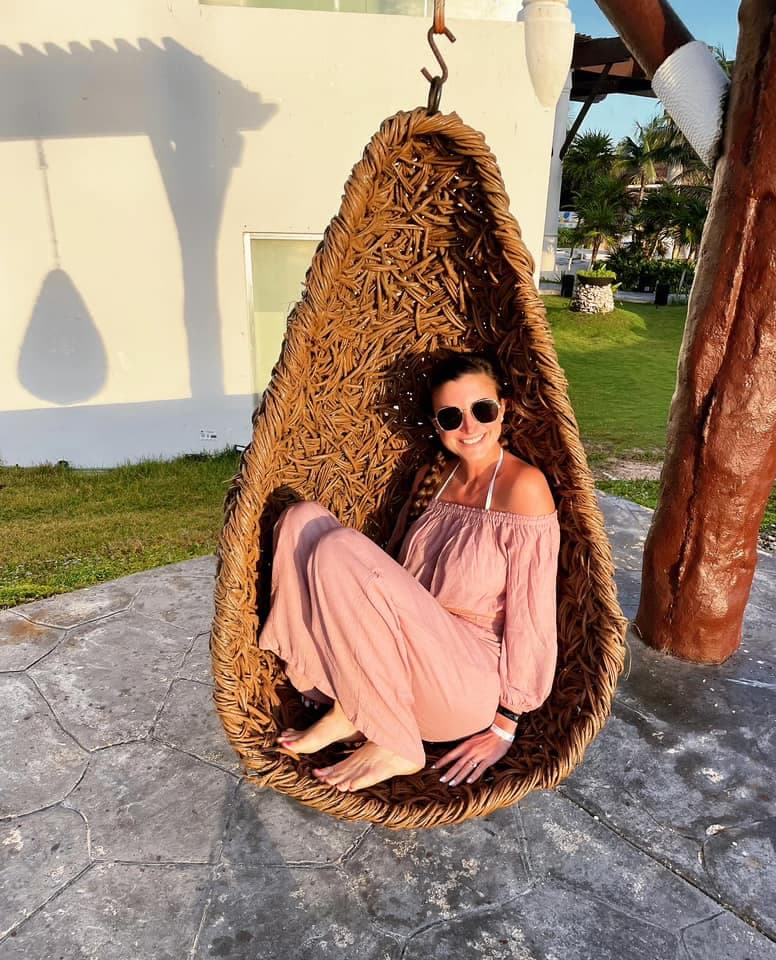 Girl on swing wearing sun glasses.