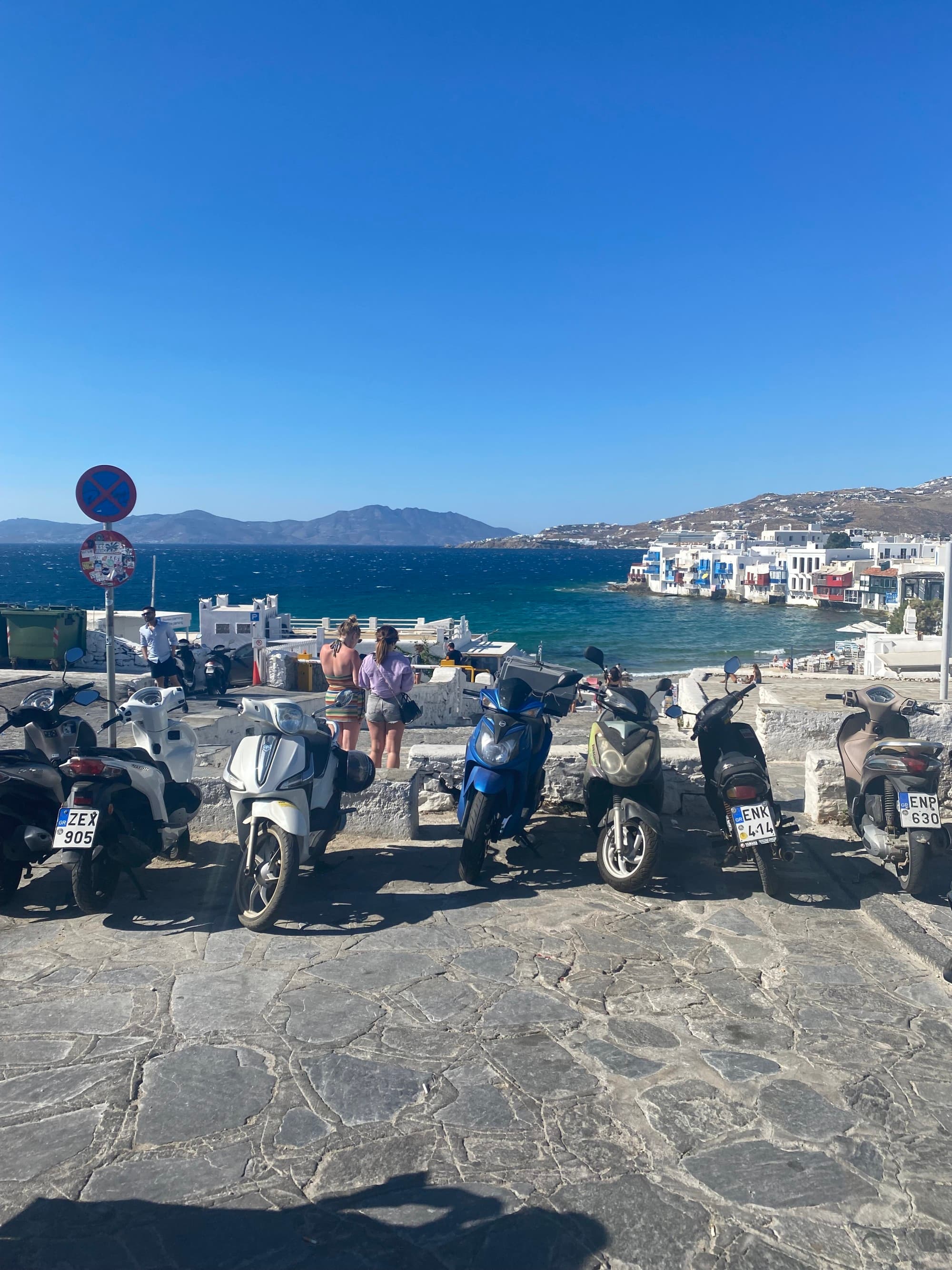 Motor Bikes parked by side of water body.