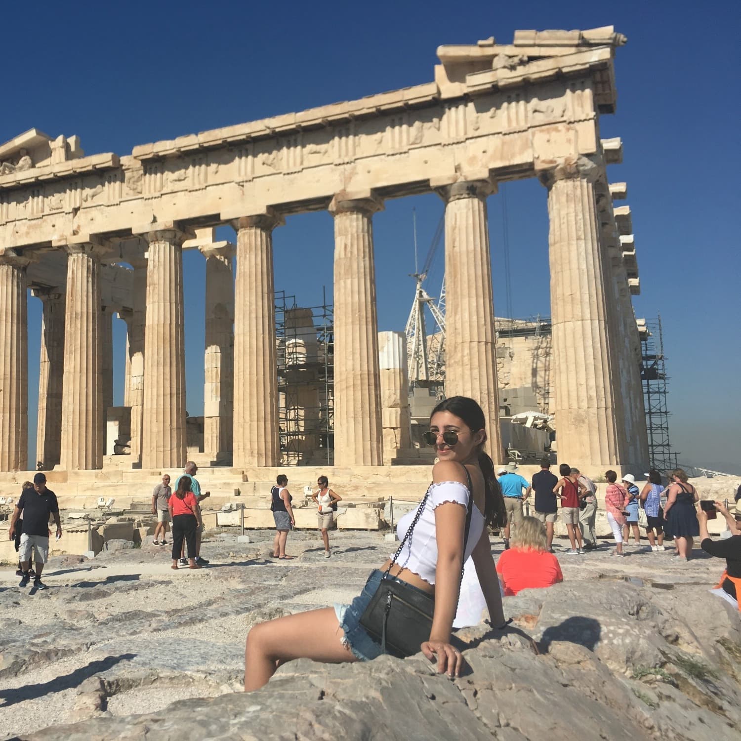 Travel advisor in front of a building ruin with pillars.
