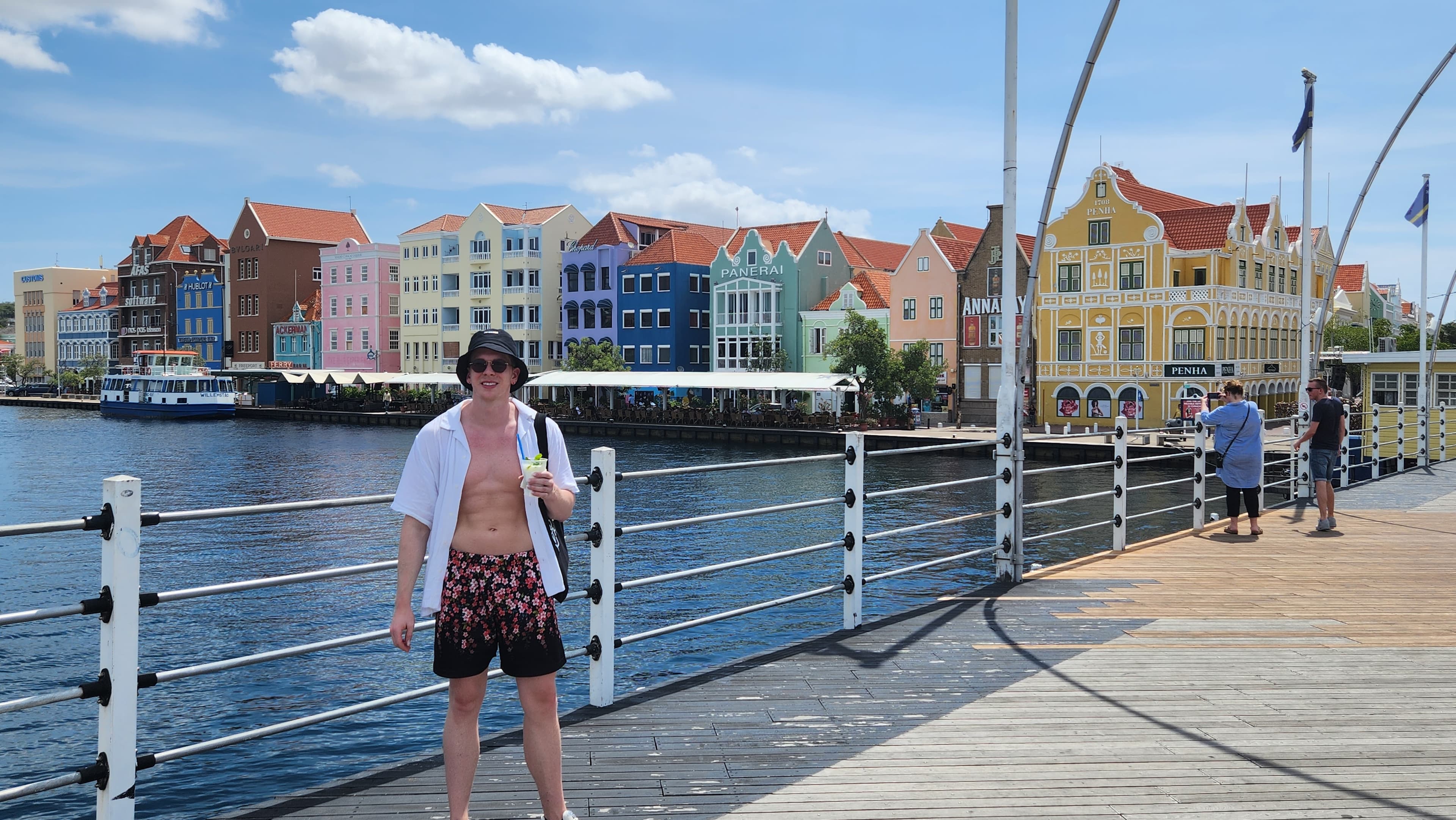 Lucas standing on a boardwalk with water and colorful buildings in the background