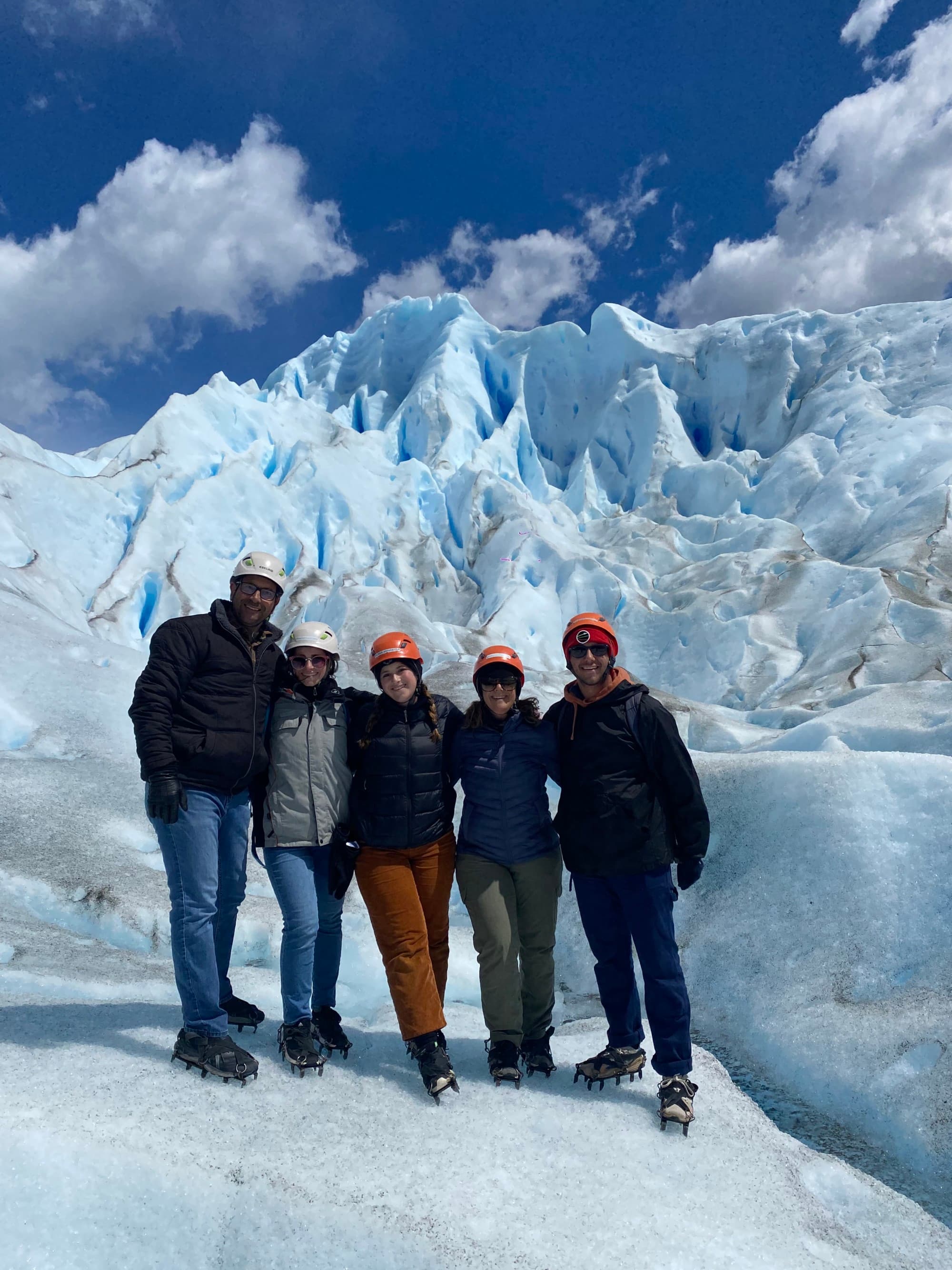 Travel advisor with a group of people in front of snowy hills.