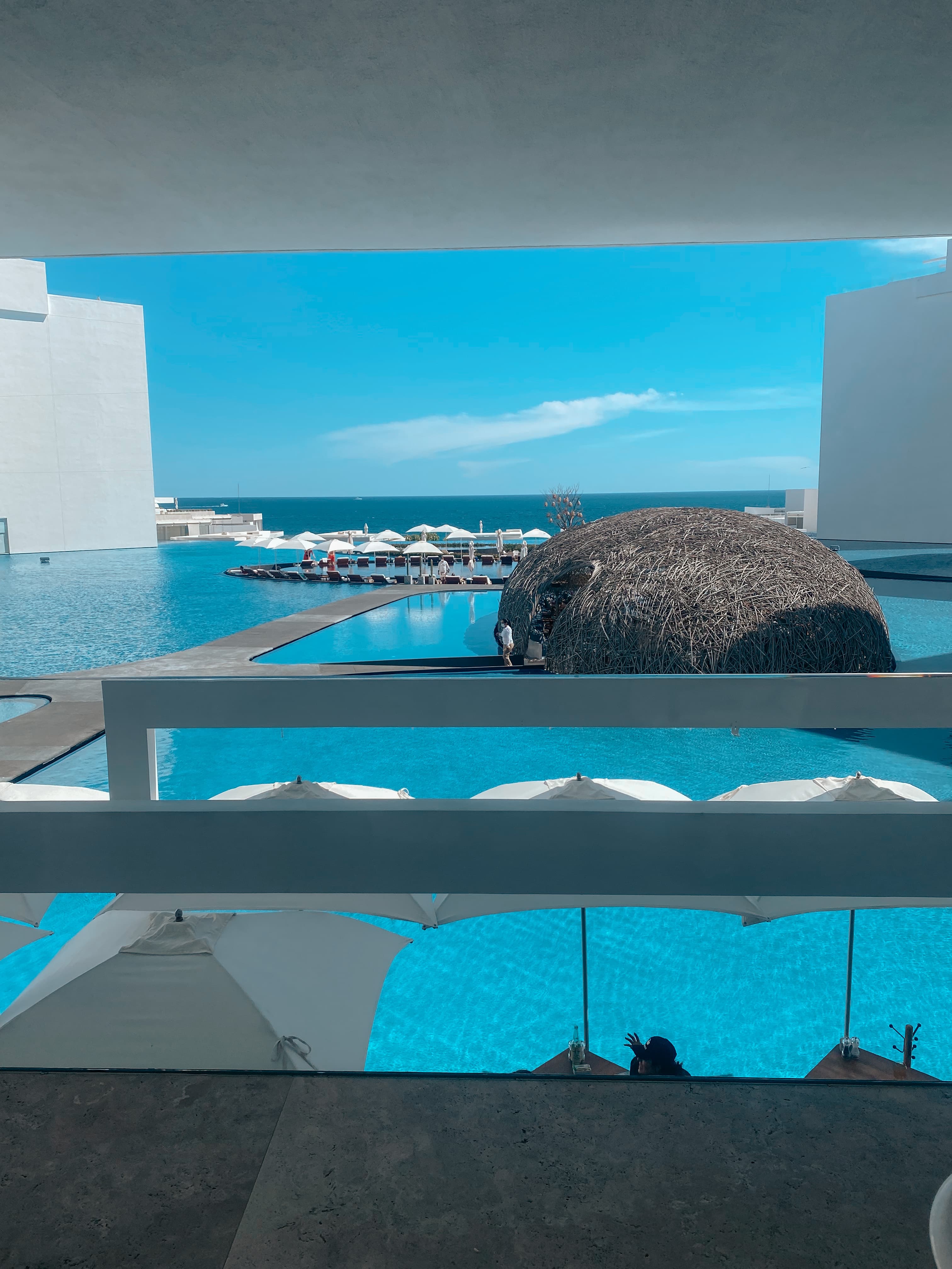 A pool with white umbrellas.