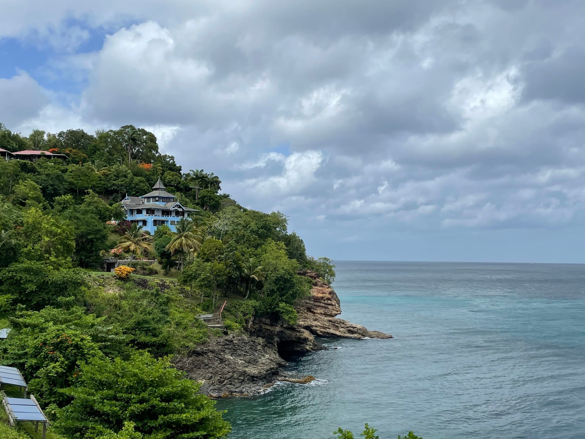 blue building on a lush oceanside cliff