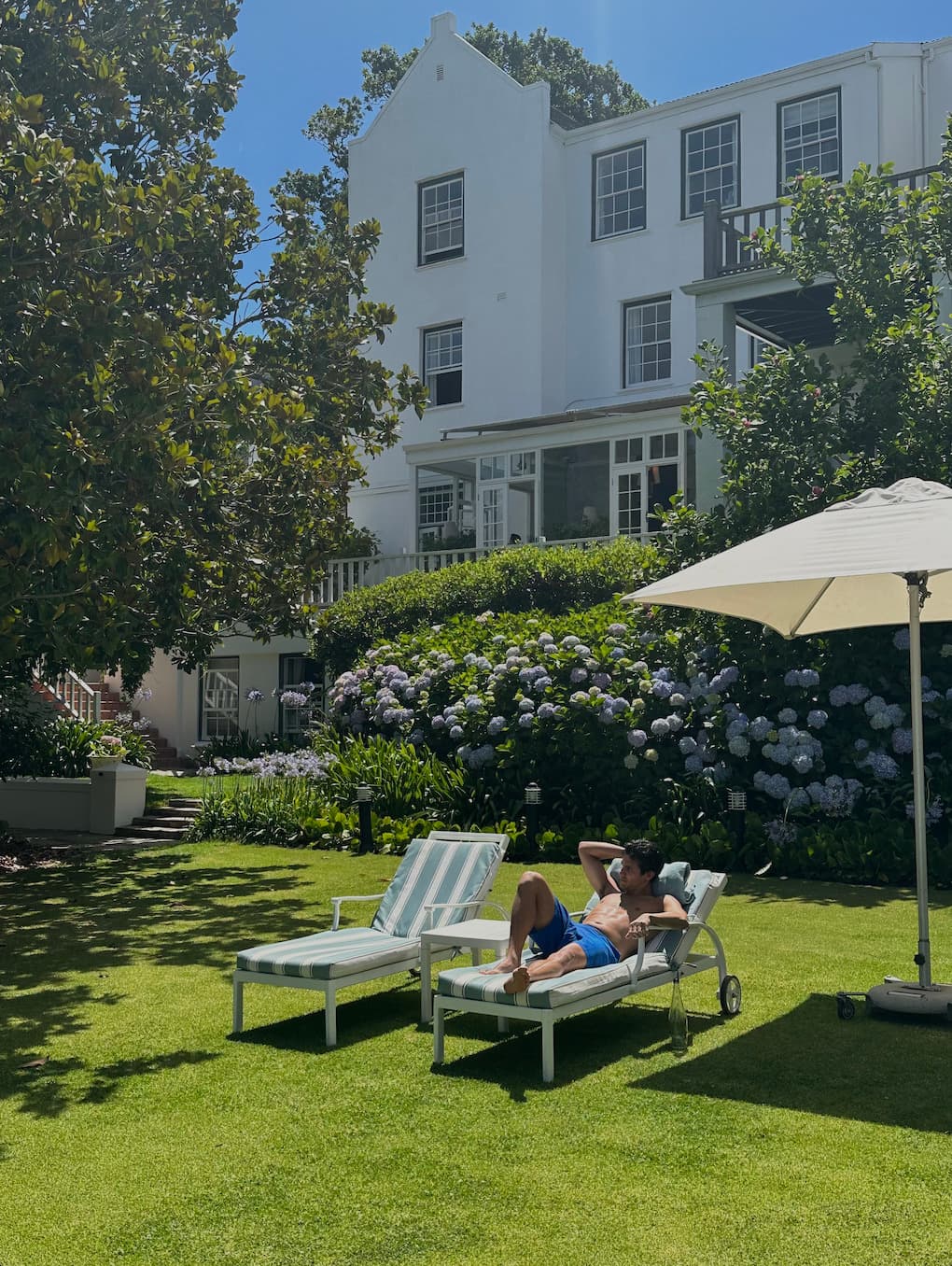 Picture of sunloungers and straw umbrella outside house