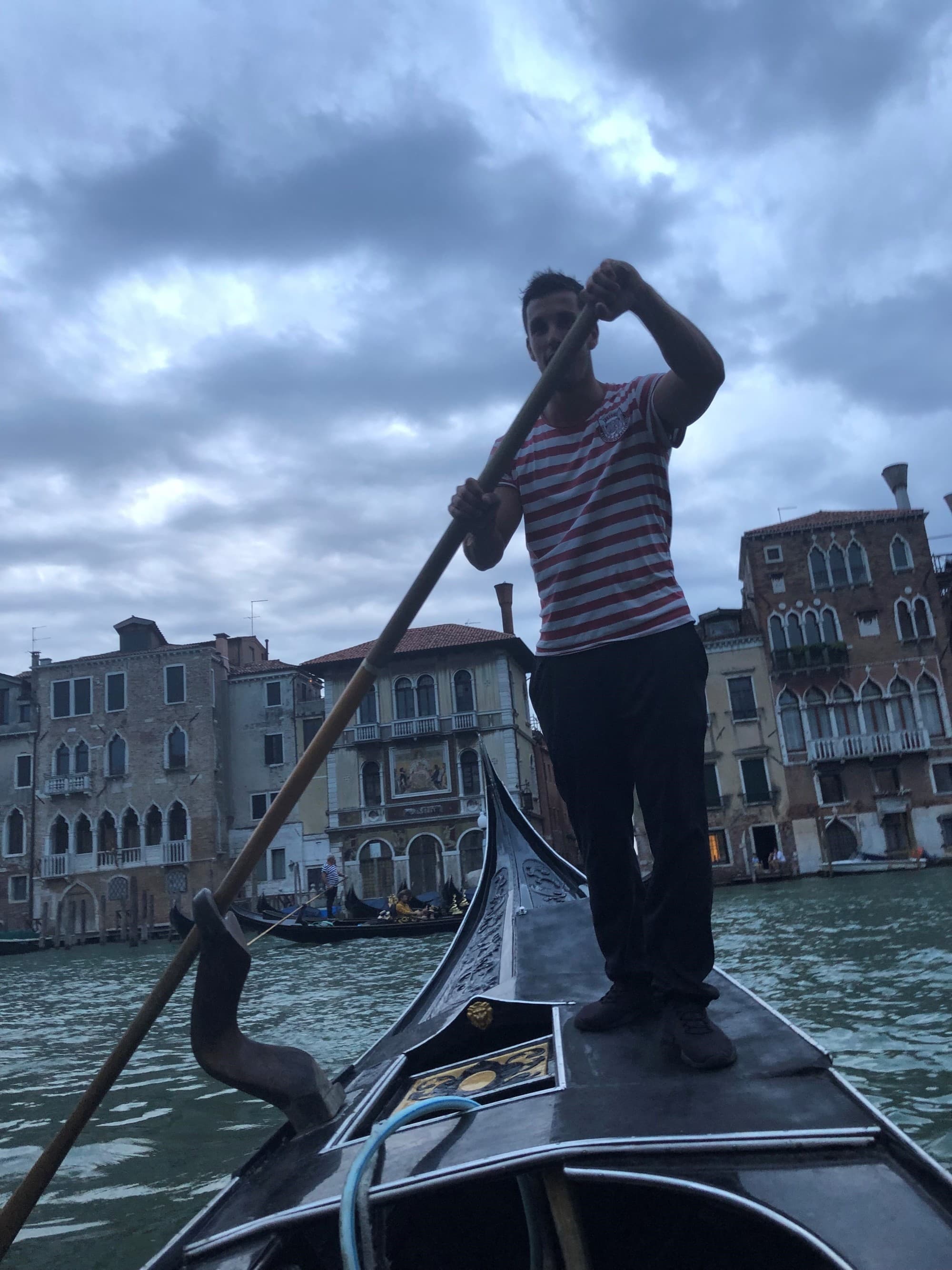 A man rowing the boat in city canal.