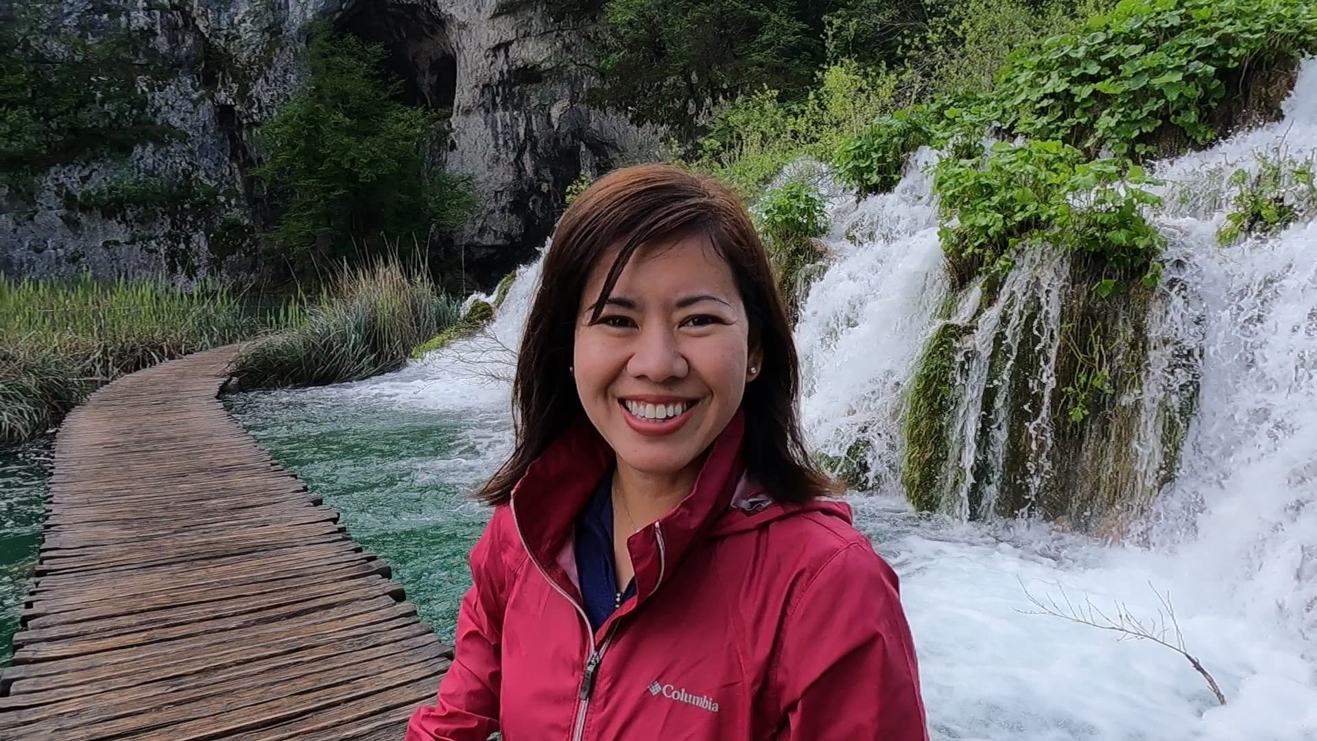 Travel advisor posing beside waterfall