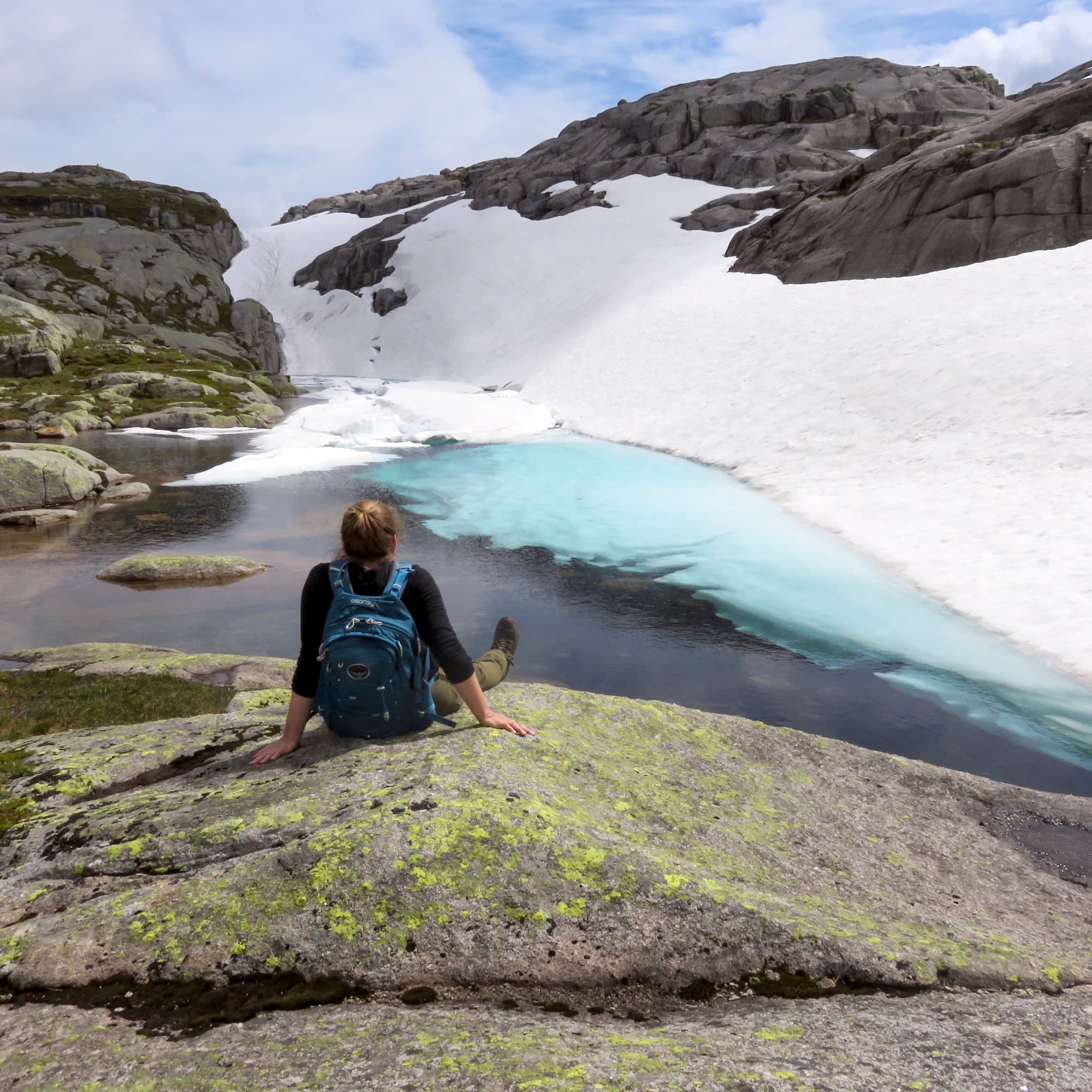 woman sits on rock on a glacier