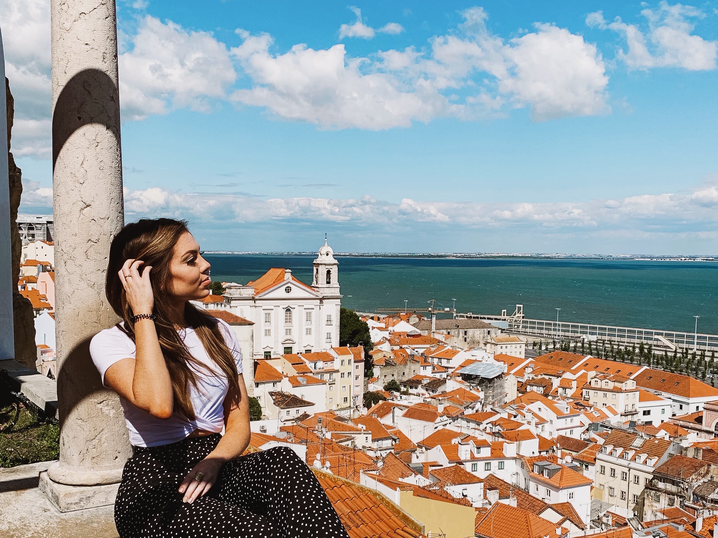 Looking at the beautiful views of Lisbon with terracotta rooftops and the sea in the background