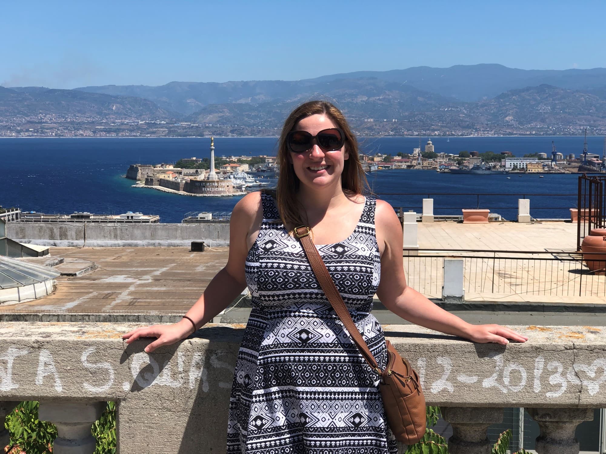 A woman with island and water body at the back.
