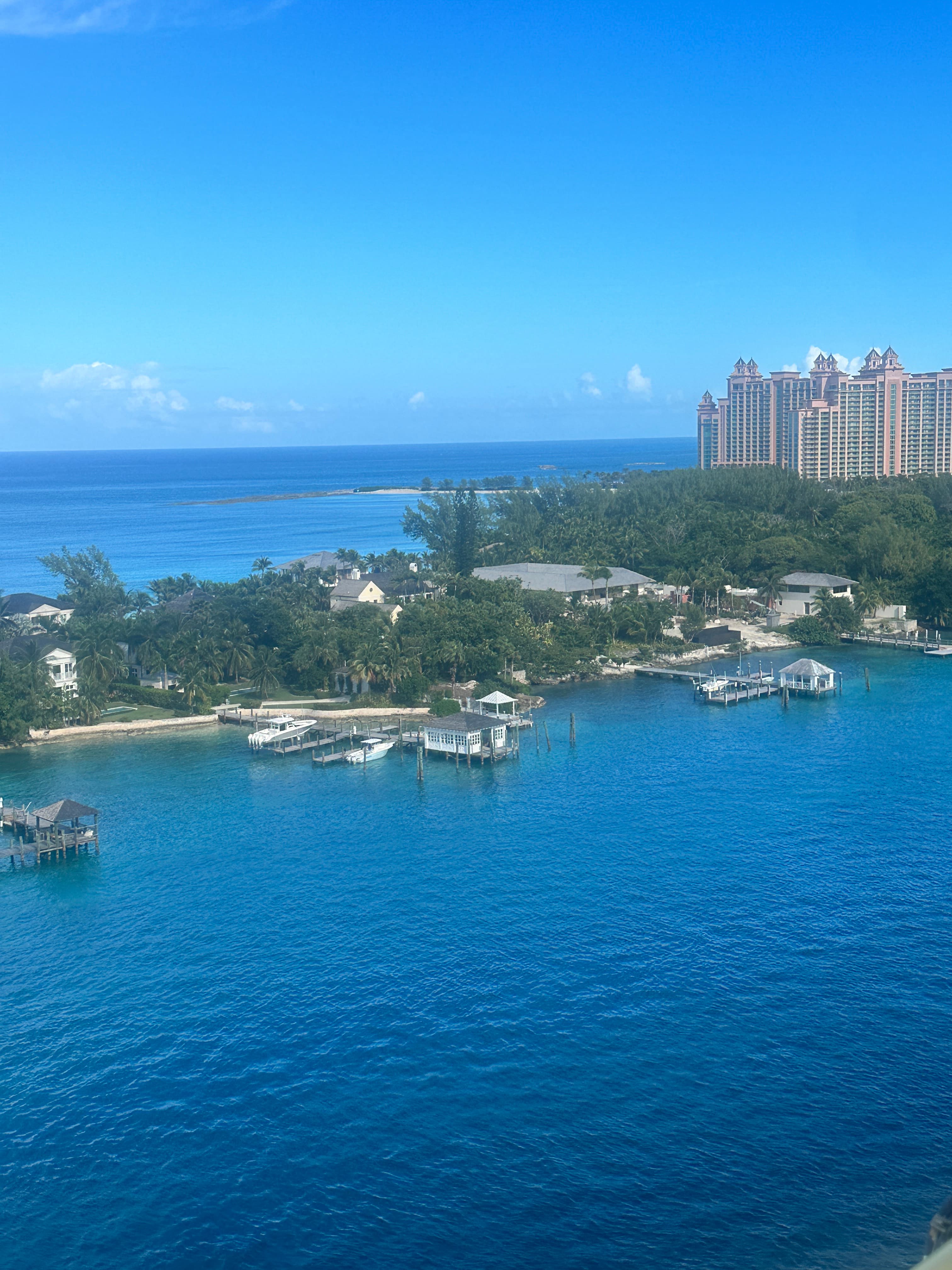 An aerial view of blue sea water surrounding a harbor with a resort building to the right