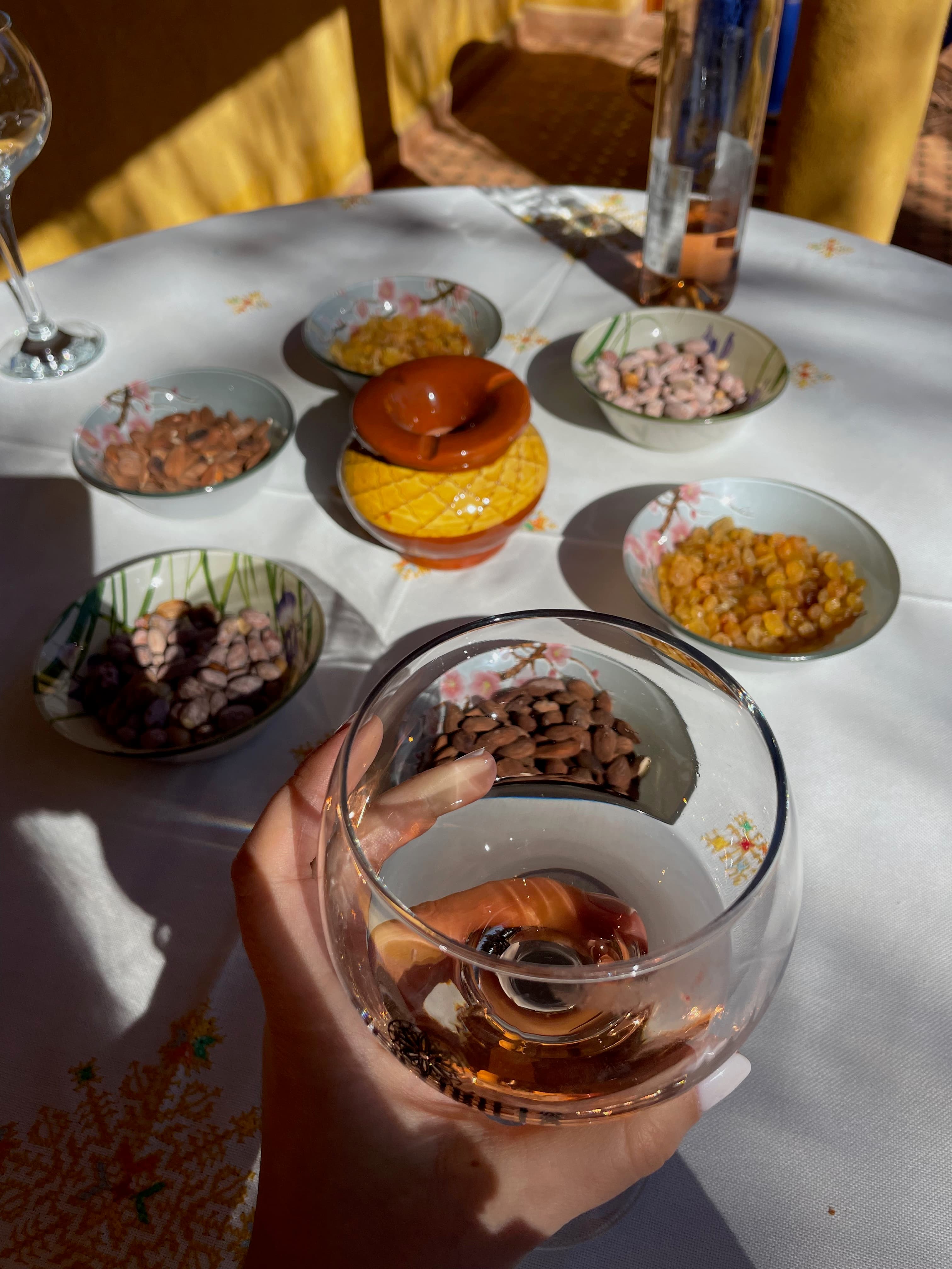 Someone holding a glass of wine above a table set with snacks on day 1 of a Morocco 7 day itinerary.